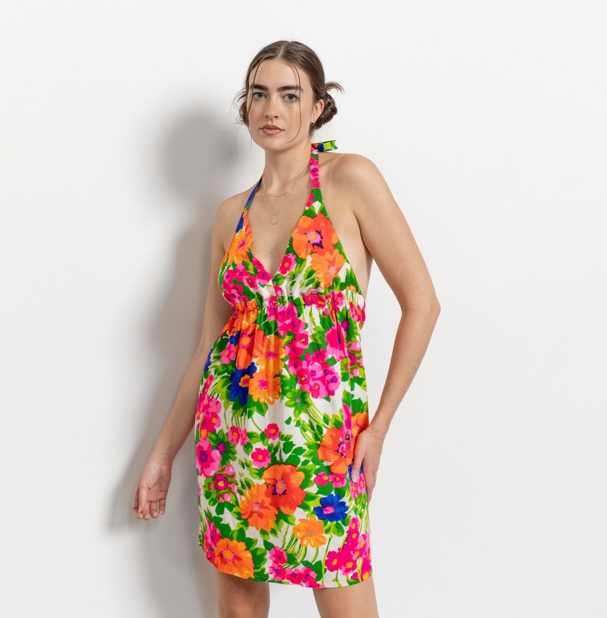 Woman wearing a colorful floral dress on a white background