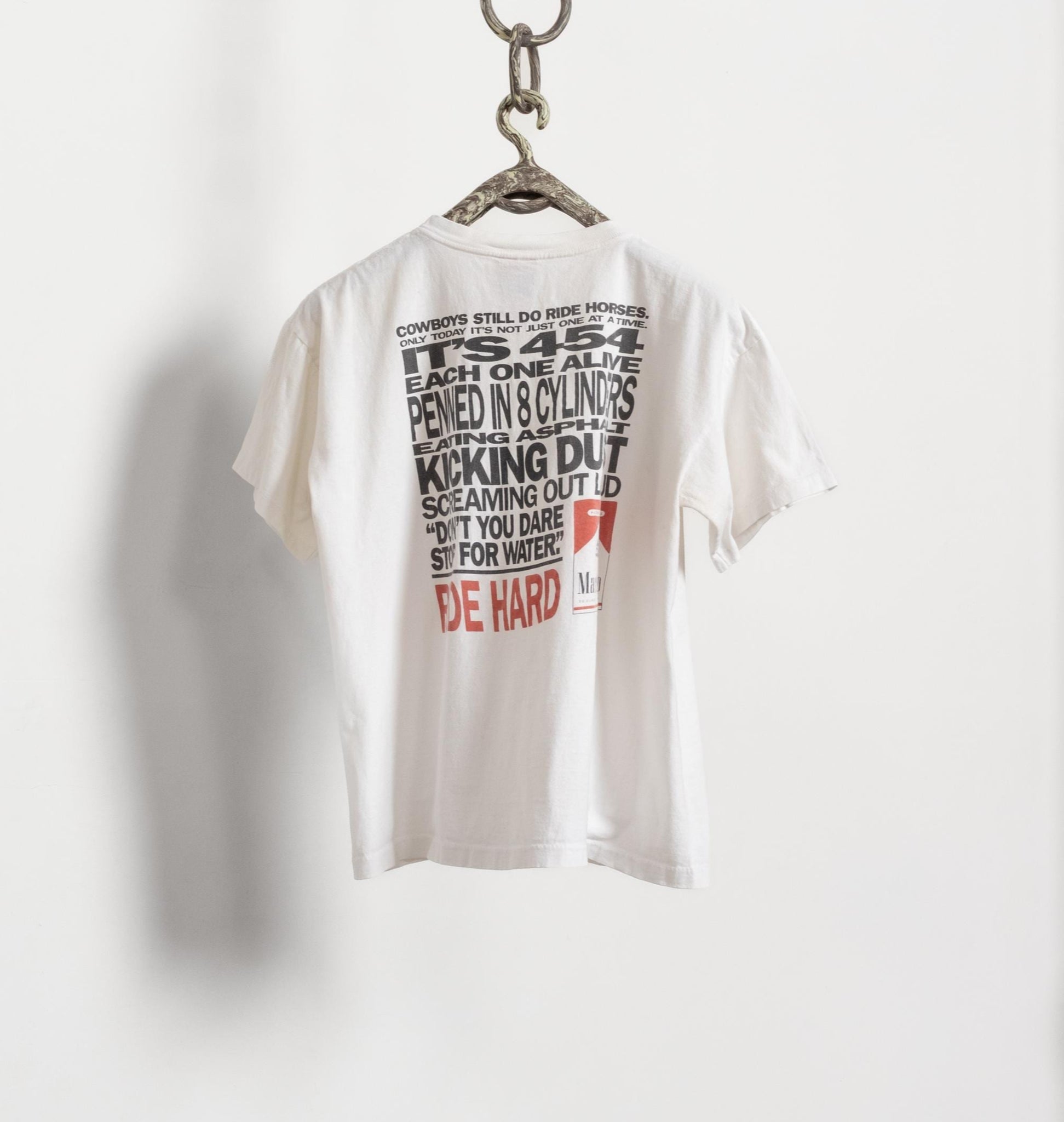 White t-shirt with text design on a hanger against a white background