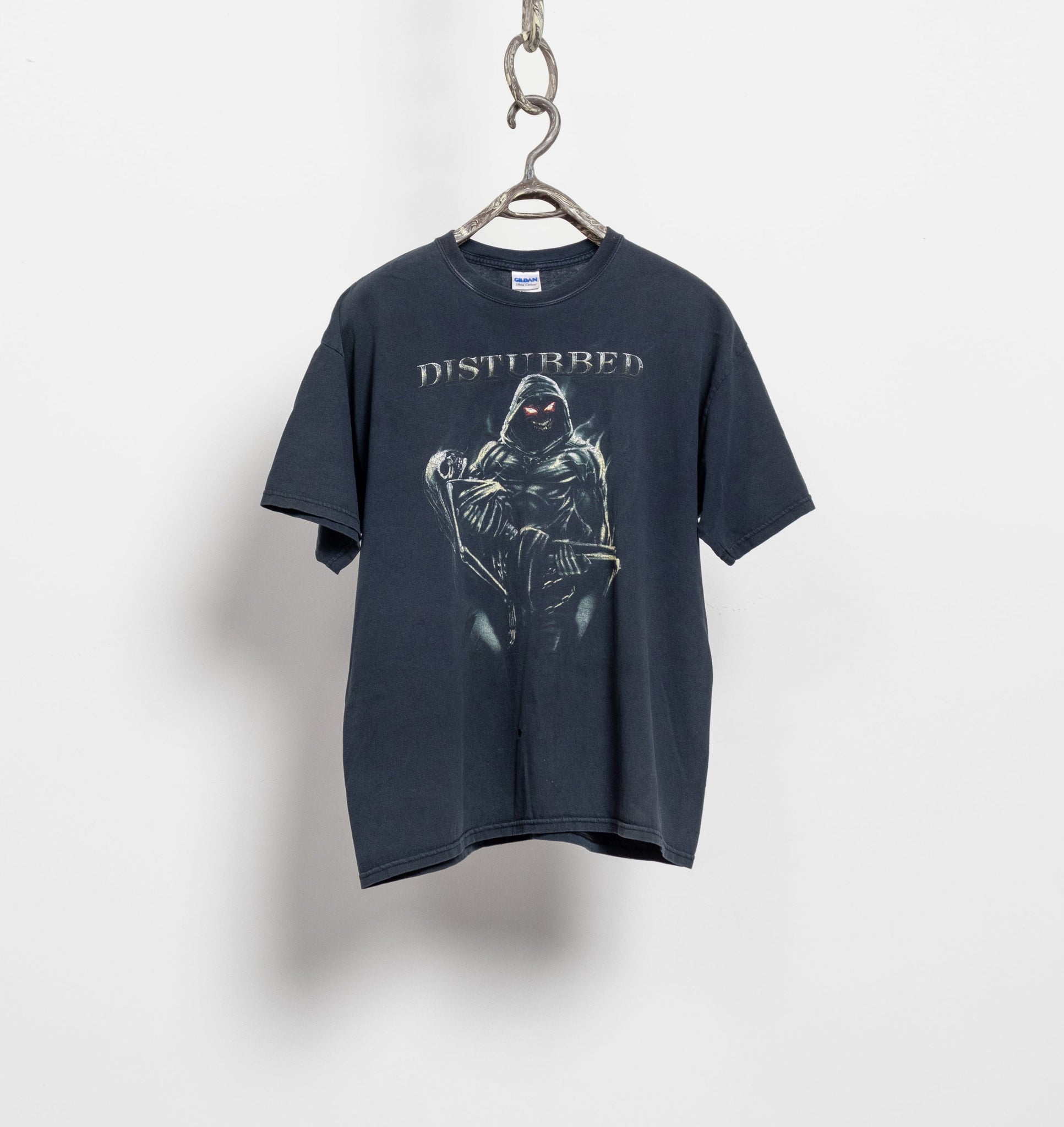 A navy-colored t-shirt with a distressed graphic print hanging on a hook against a white background.