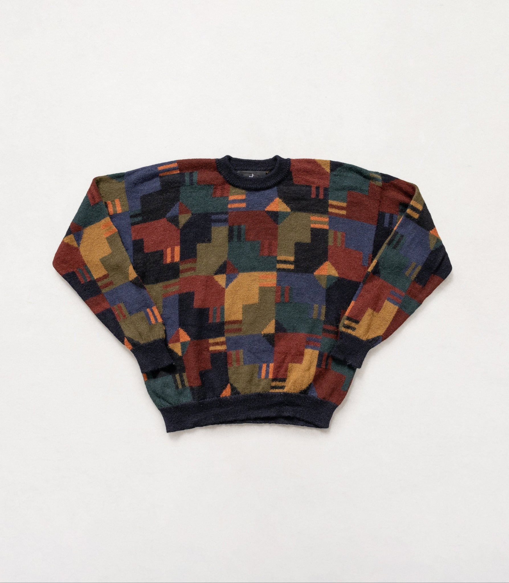 Multicolored geometric patterned sweater on a white background
