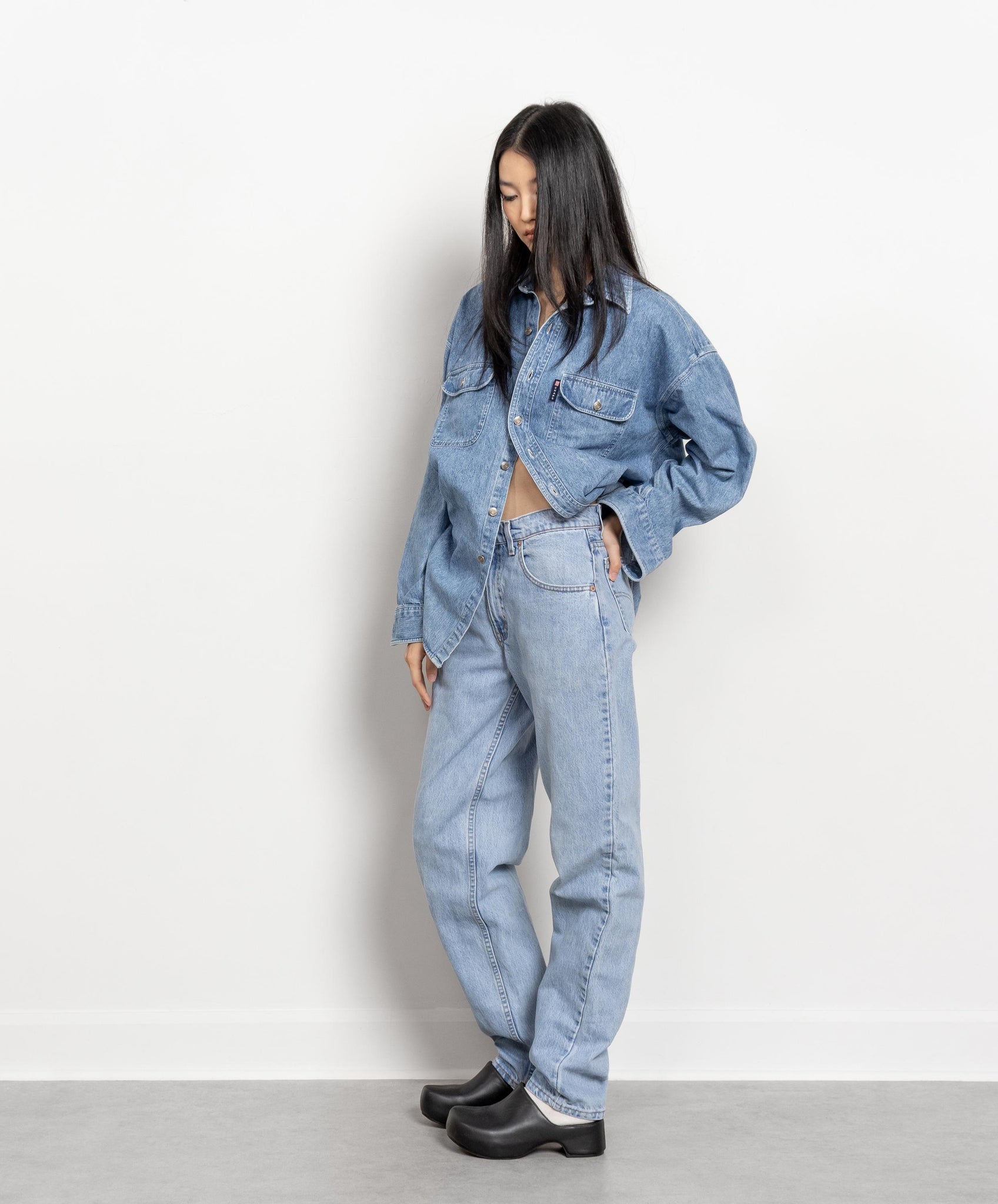 Person wearing a denim outfit against a plain background