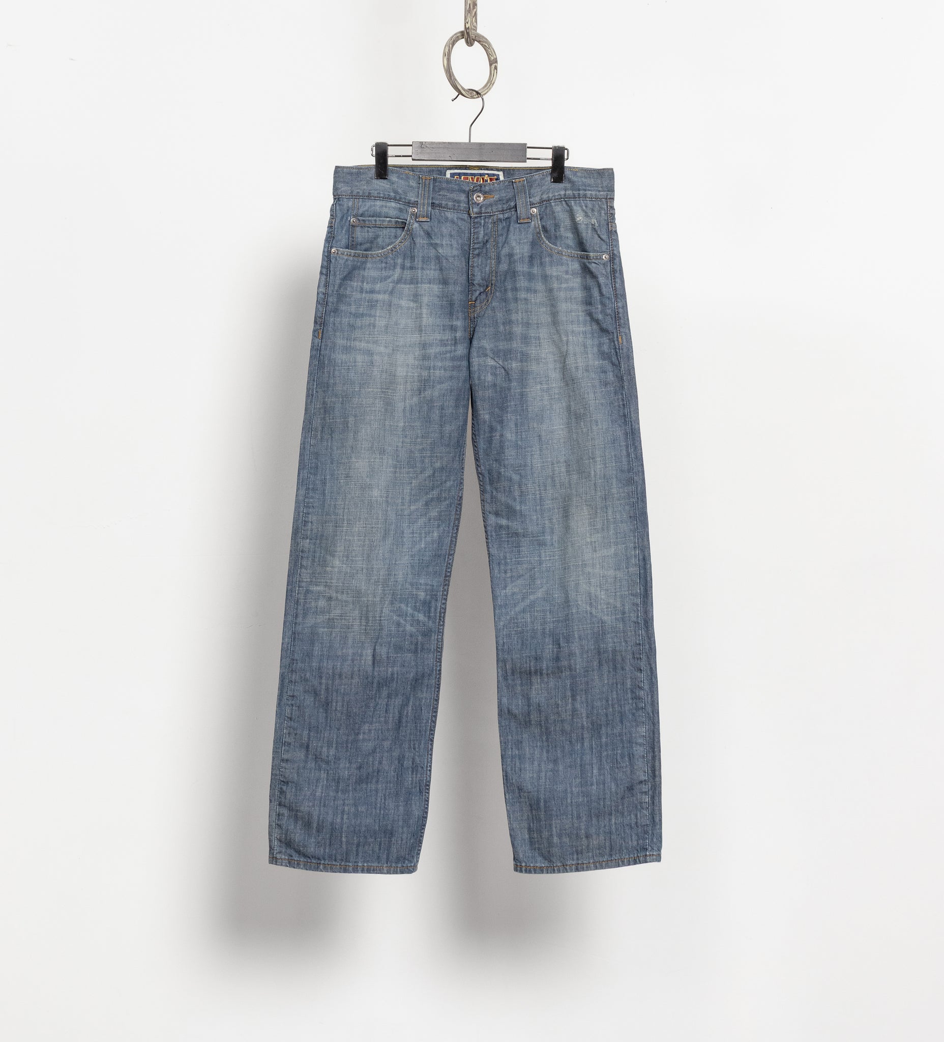 Blue jeans hanging on a white background
