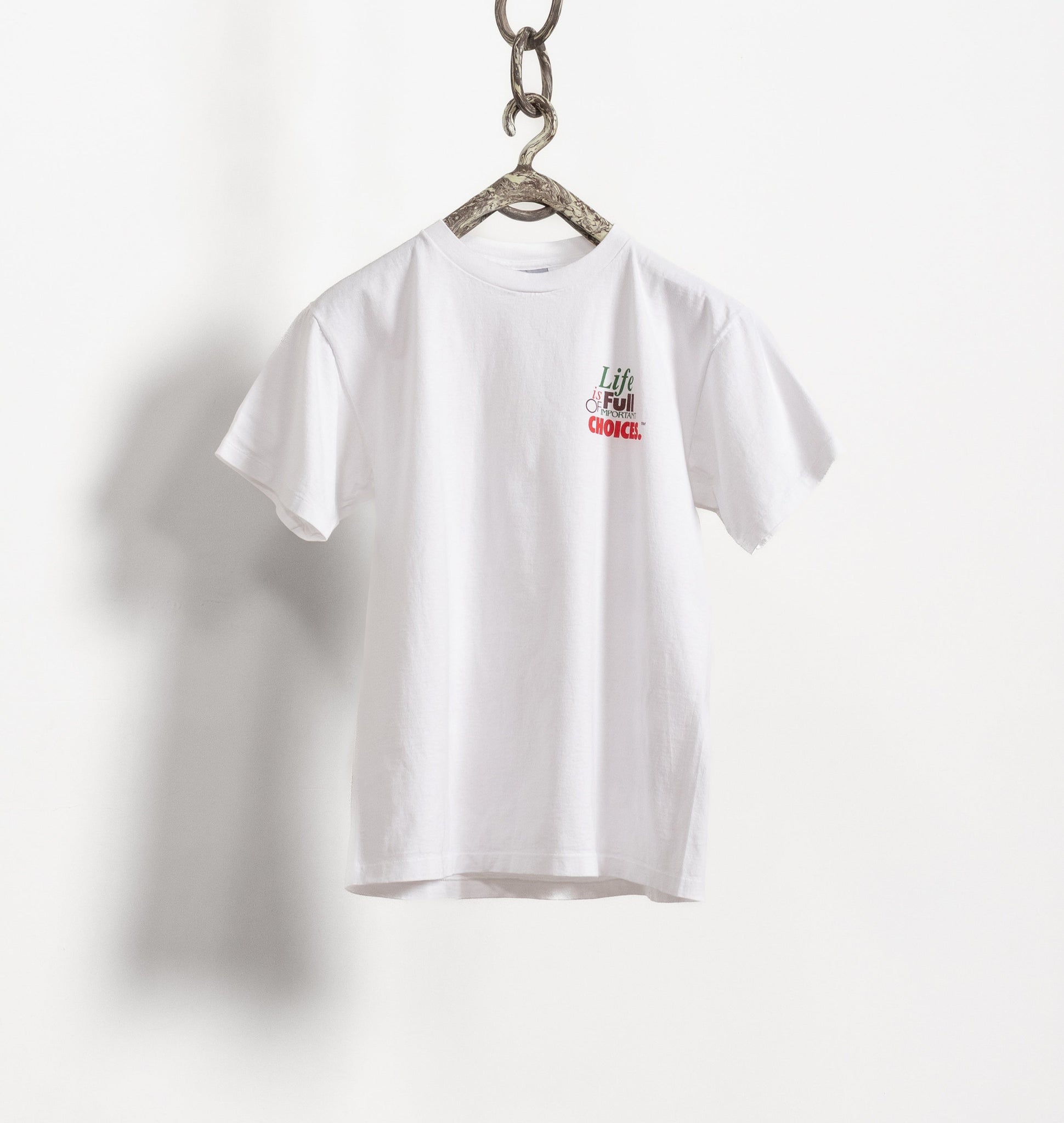 White t-shirt with a red logo on a hanger against a white background