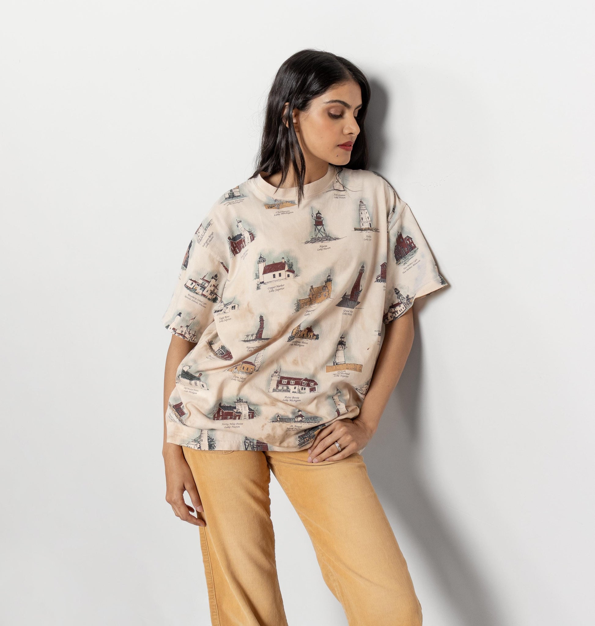 Woman wearing a patterned top and yellow pants against a white background