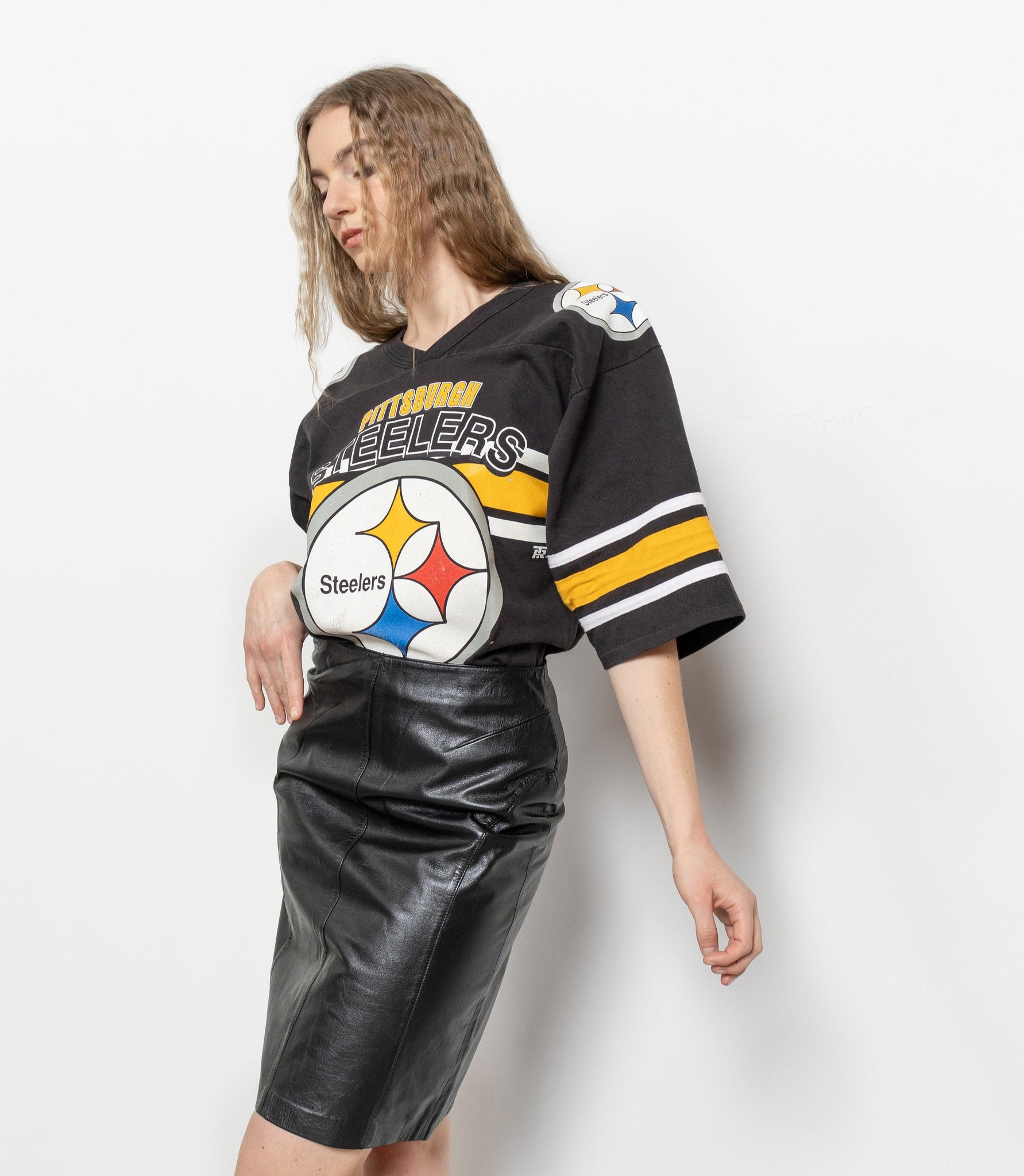 Person wearing a black sports jersey with a logo on a white background