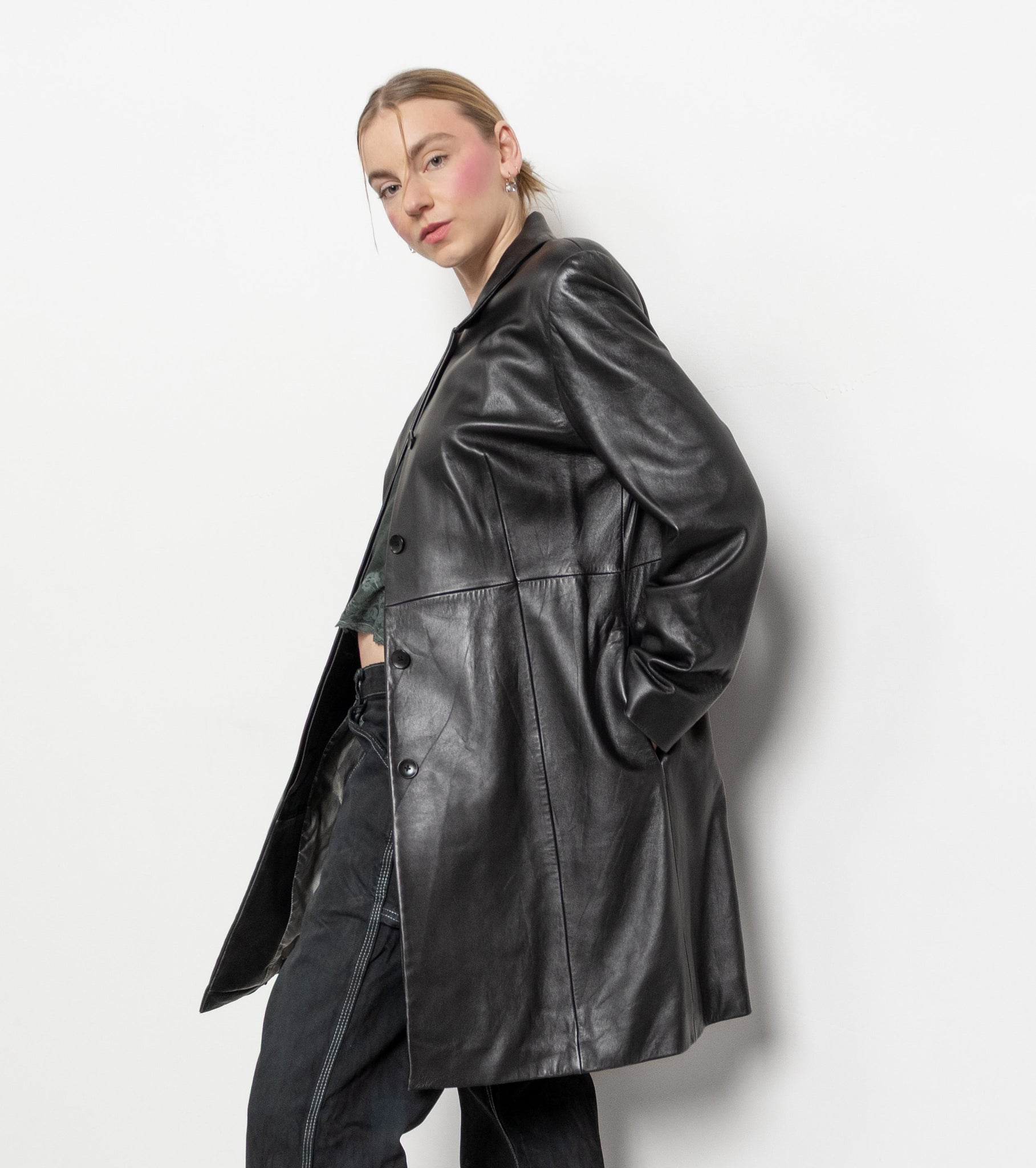 Person wearing a black leather coat against a white background
