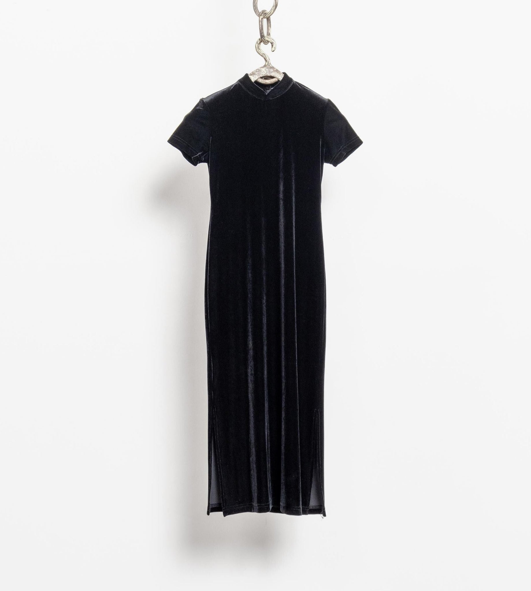 A vintage 90's black stretch velvet short sleeve maxi dress hanging against a white background.
