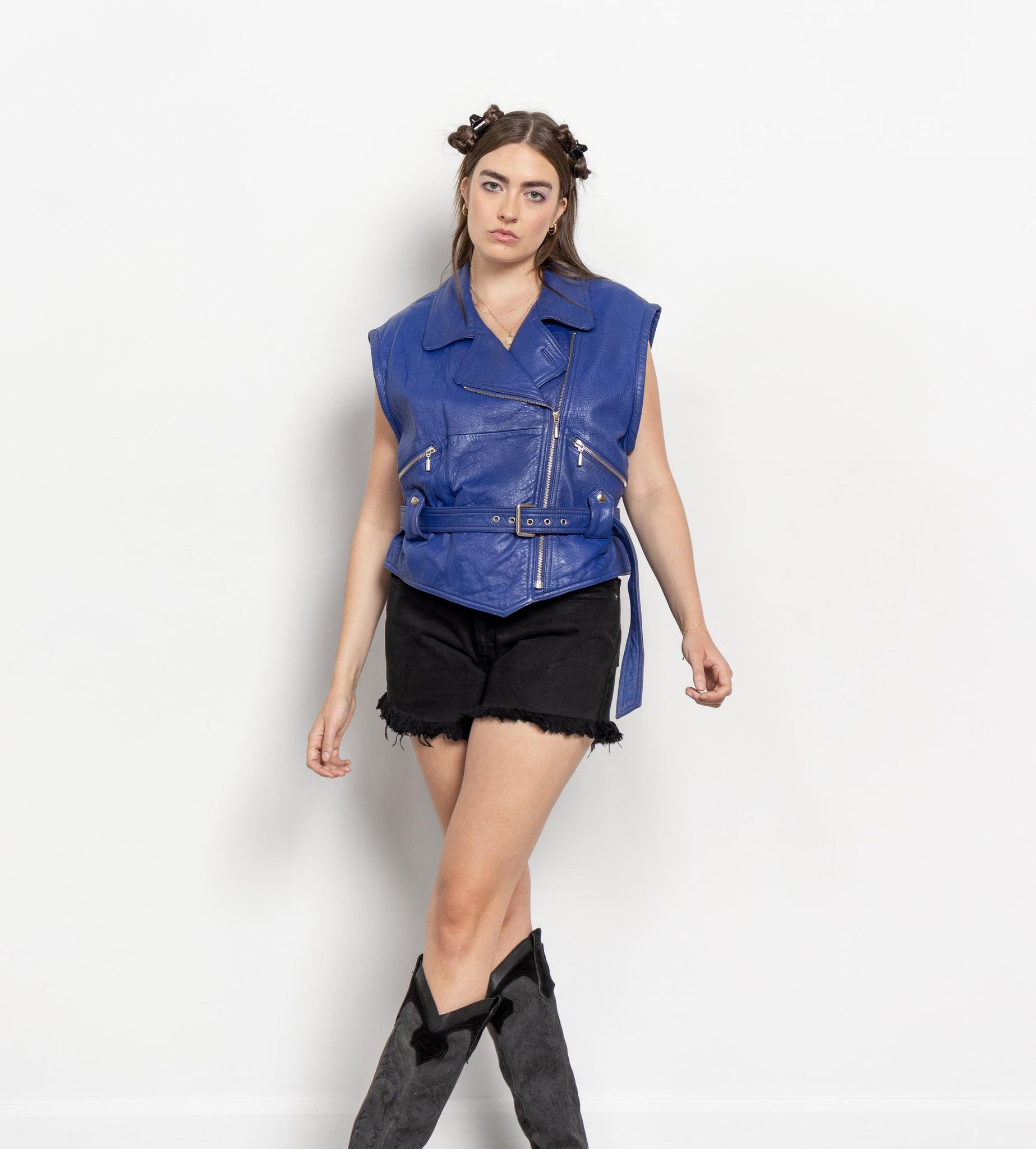 Person wearing a blue sleeveless jacket on a white background