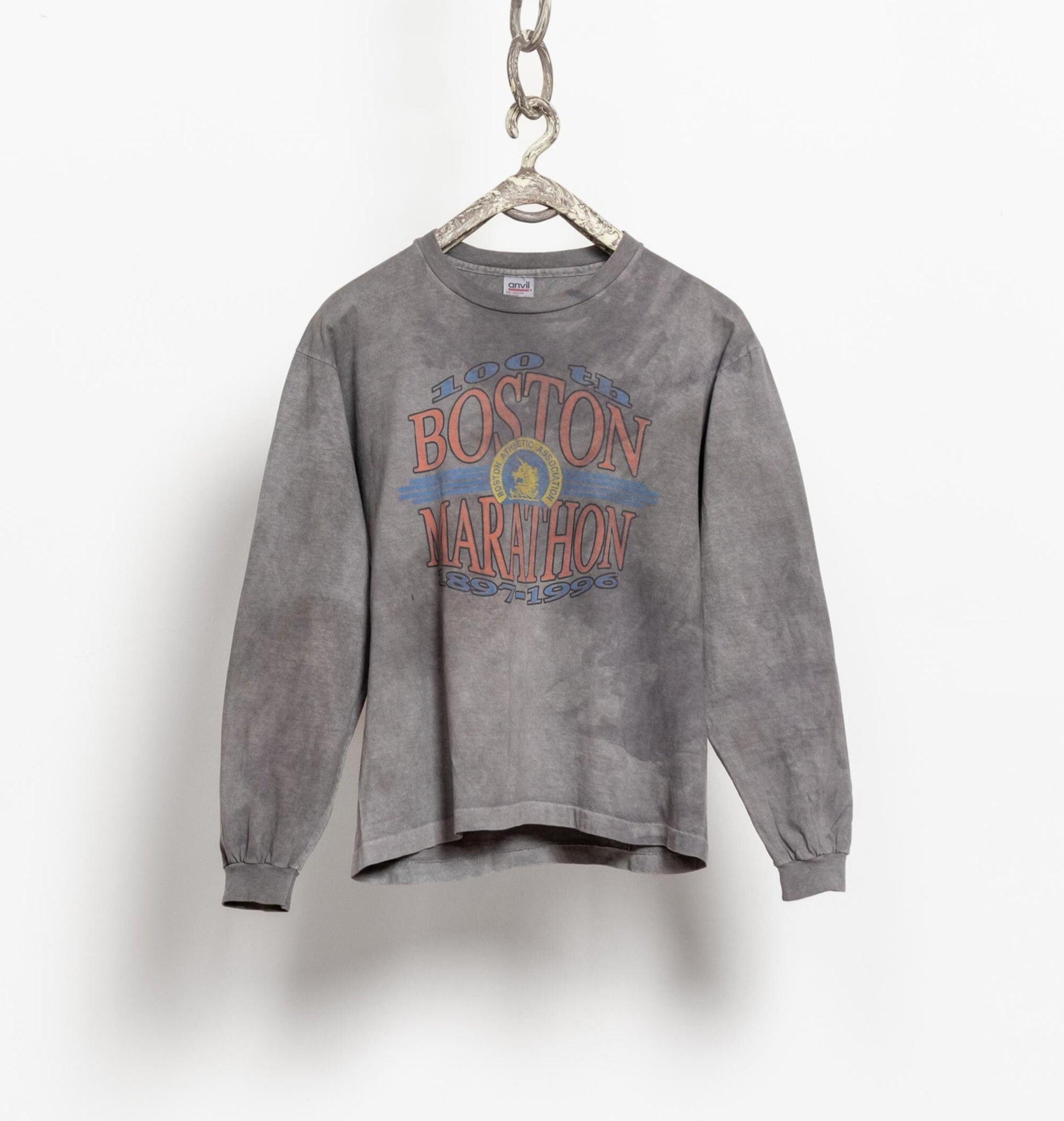 Gray sweatshirt with 'Boston Marathon' text on a hanger against a white background
