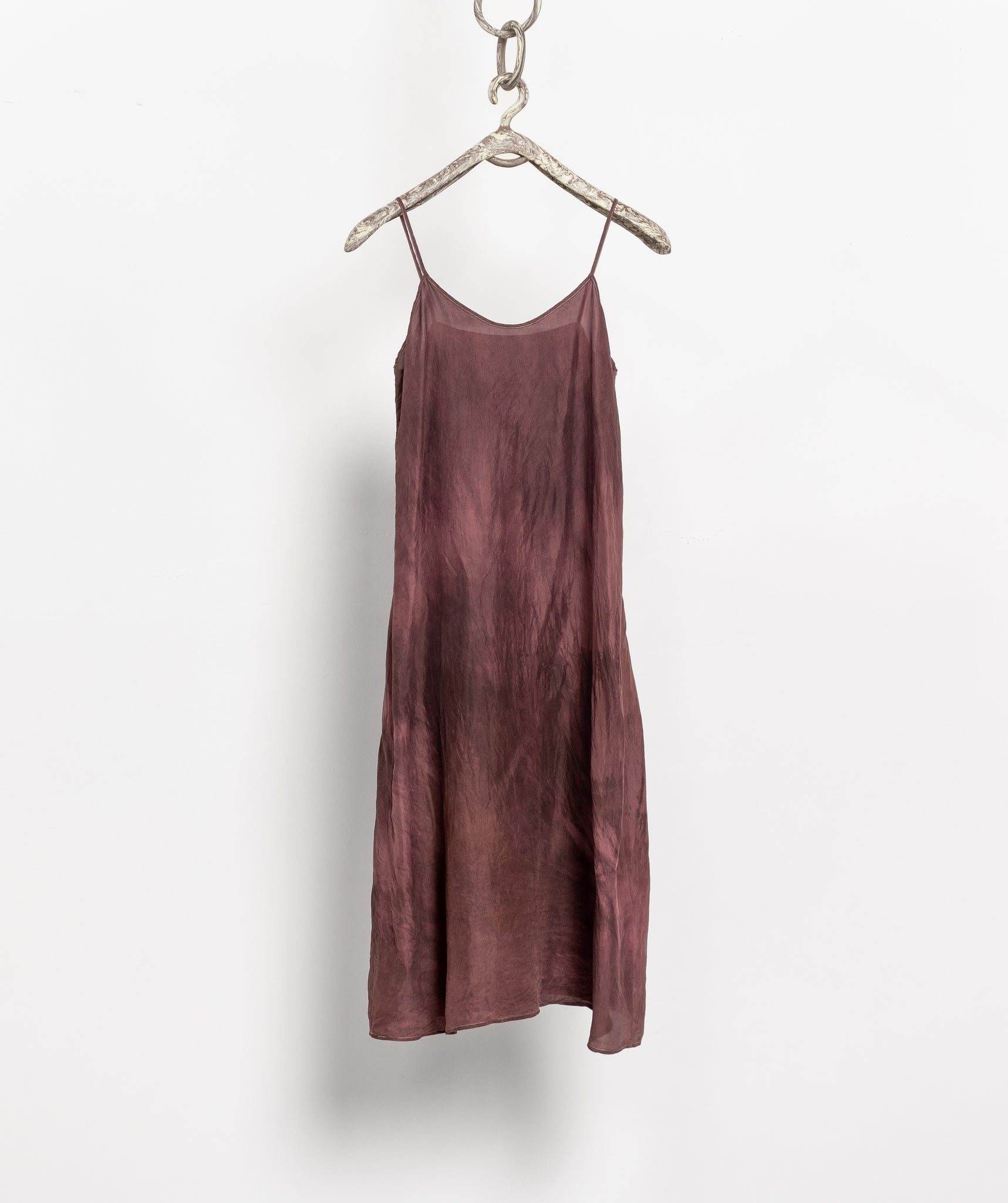 Mauve slip dress hanging on a white background