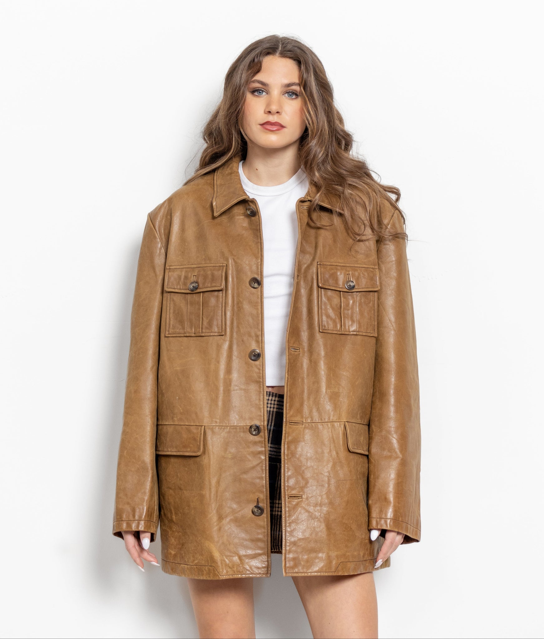 Woman wearing a brown leather jacket on a white background