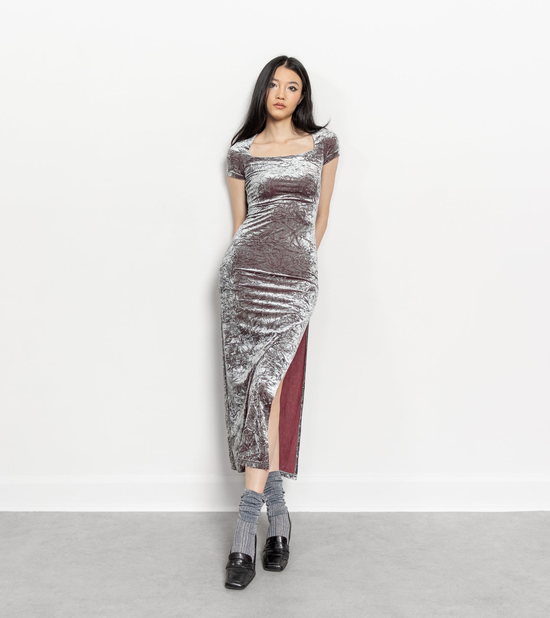 Woman wearing a metallic silver dress with a white background