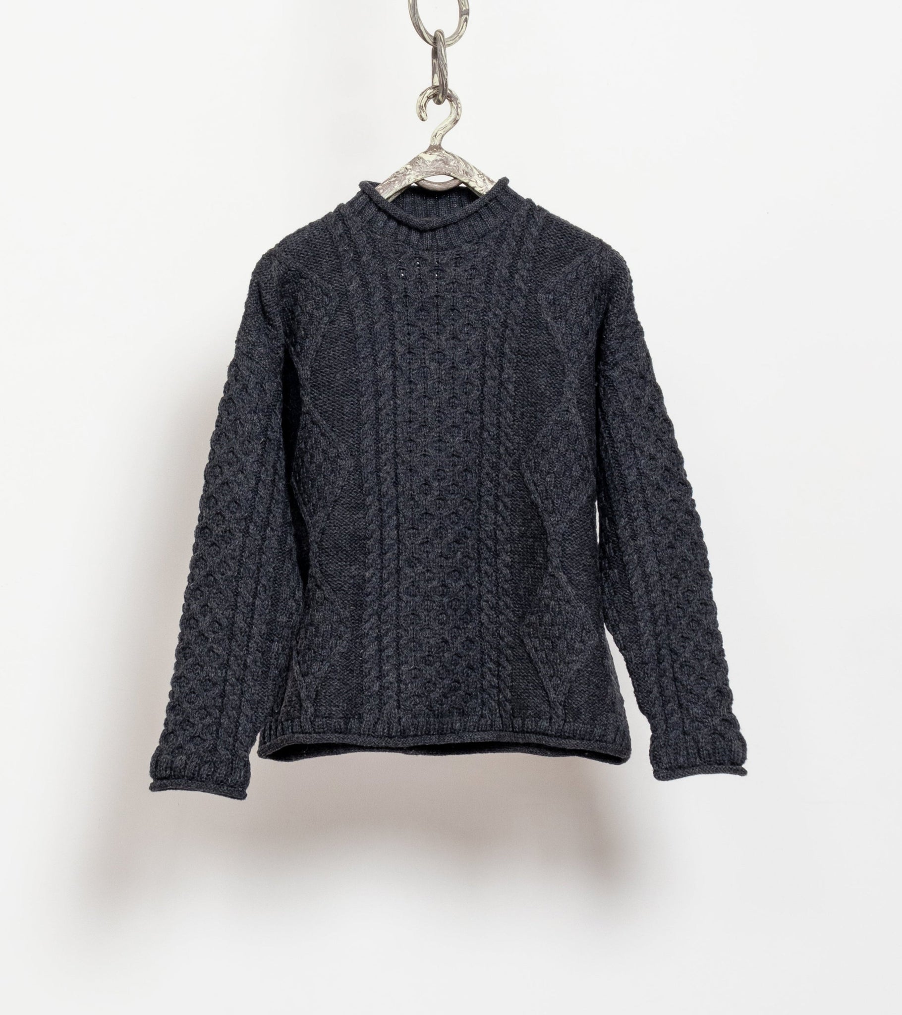 Dark gray cable knit sweater on a hanger against a white background