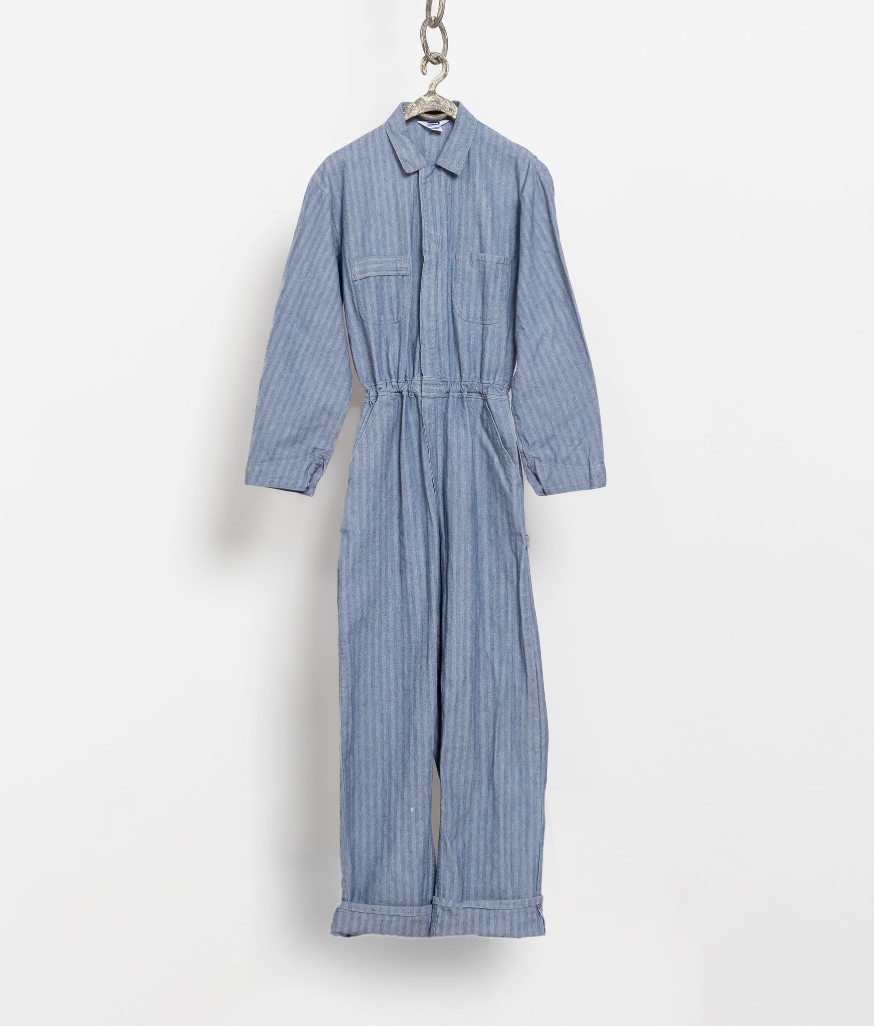 Blue striped jumpsuit hanging on a white background