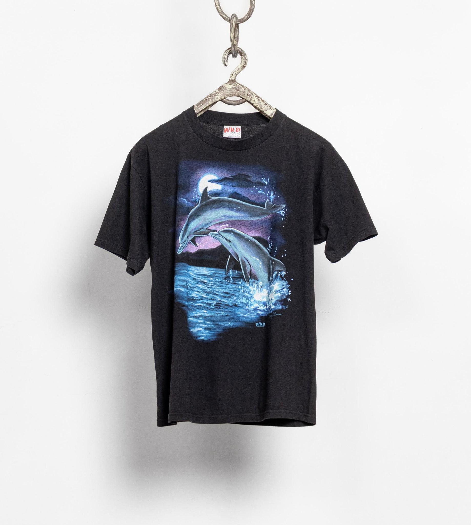 Black t-shirt with a dolphin graphic on a hanger against a white background