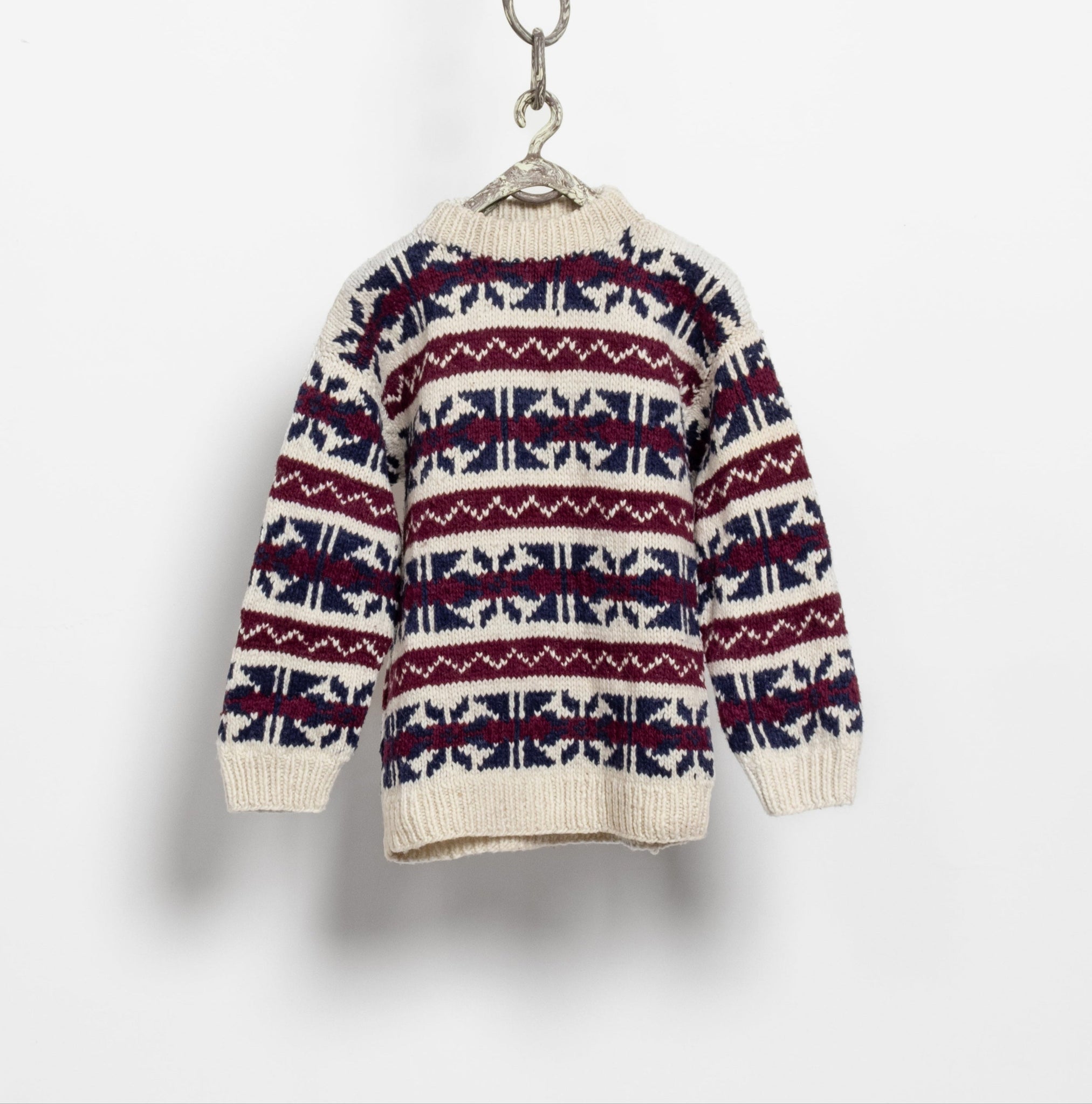 A vintage 90's chunky hand knit oversized sweater with a fair isle pattern in burgundy, navy, and cream colors, displayed on a white background.