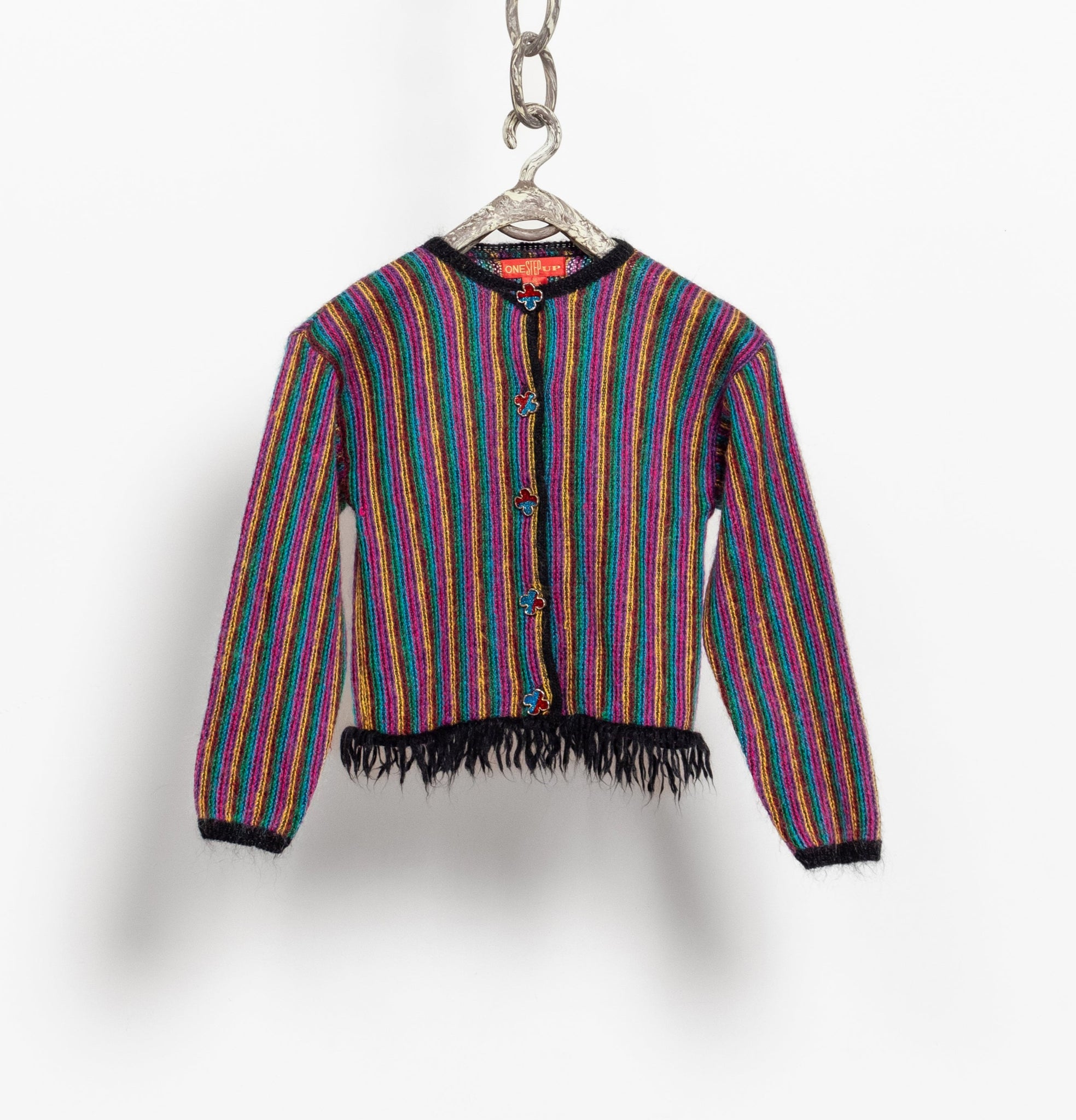 Multicolored striped jacket with fringe on a hanger against a white background