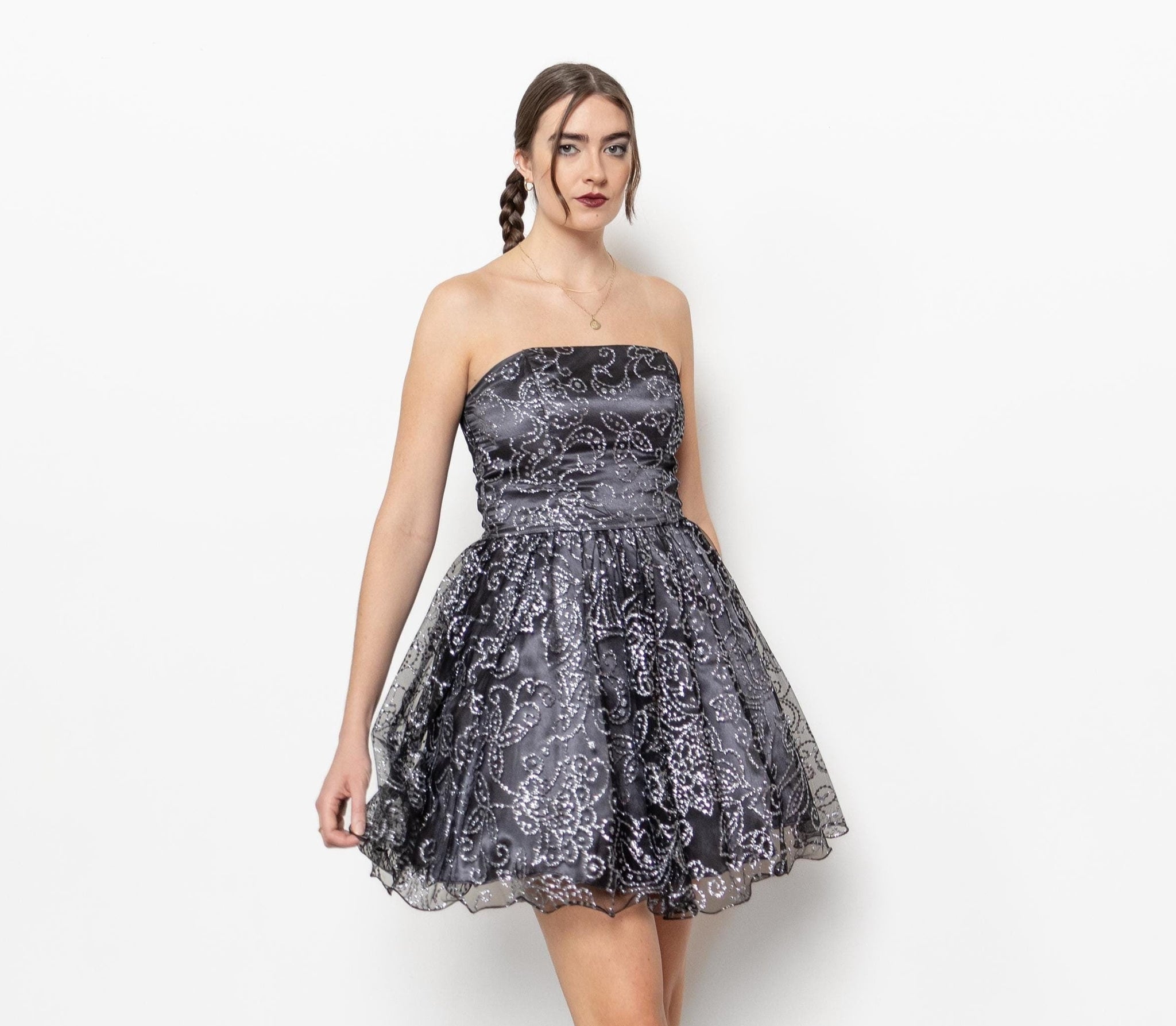 A vintage 2000's metallic poofy midi prom dress with a straight strapless neckline, boning through the corset style top, and a full pleated skirt with a glittery outer tulle layer.