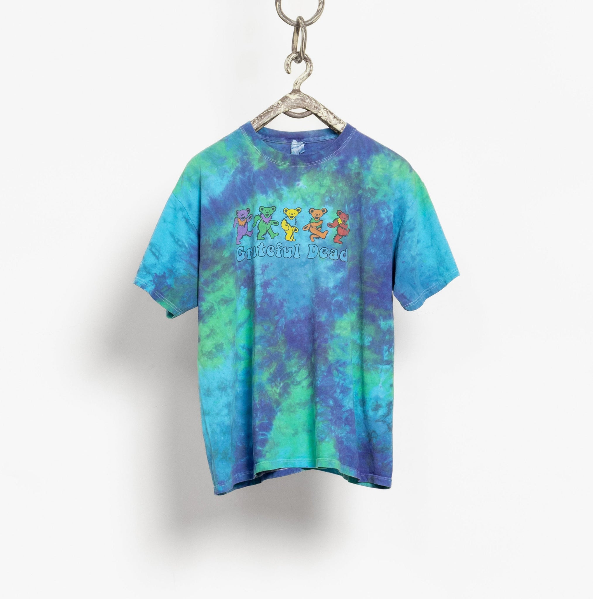 Tie-dye t-shirt with colorful design on a hanger against a white background