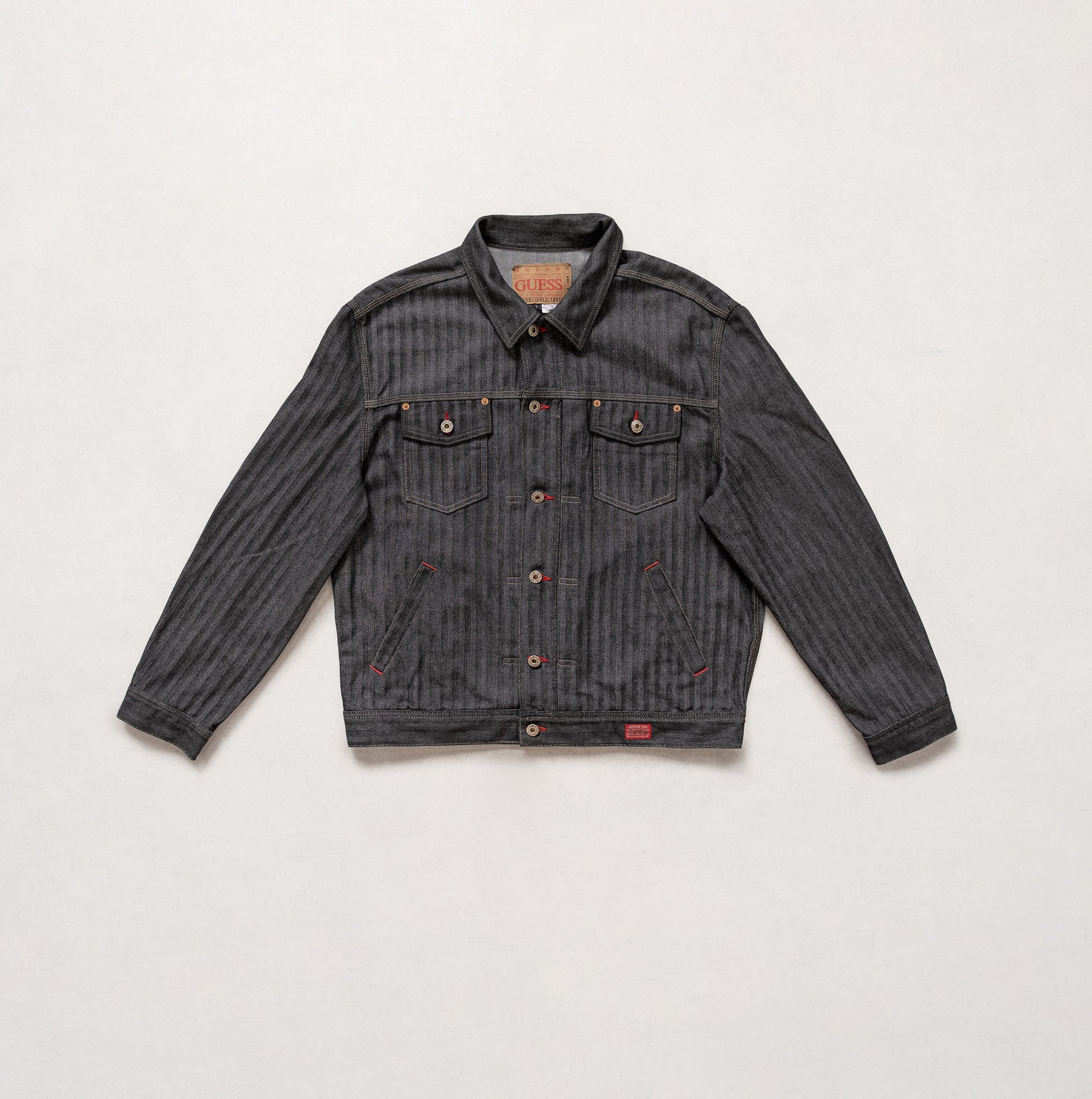 Dark denim jacket with button details on a light gray background