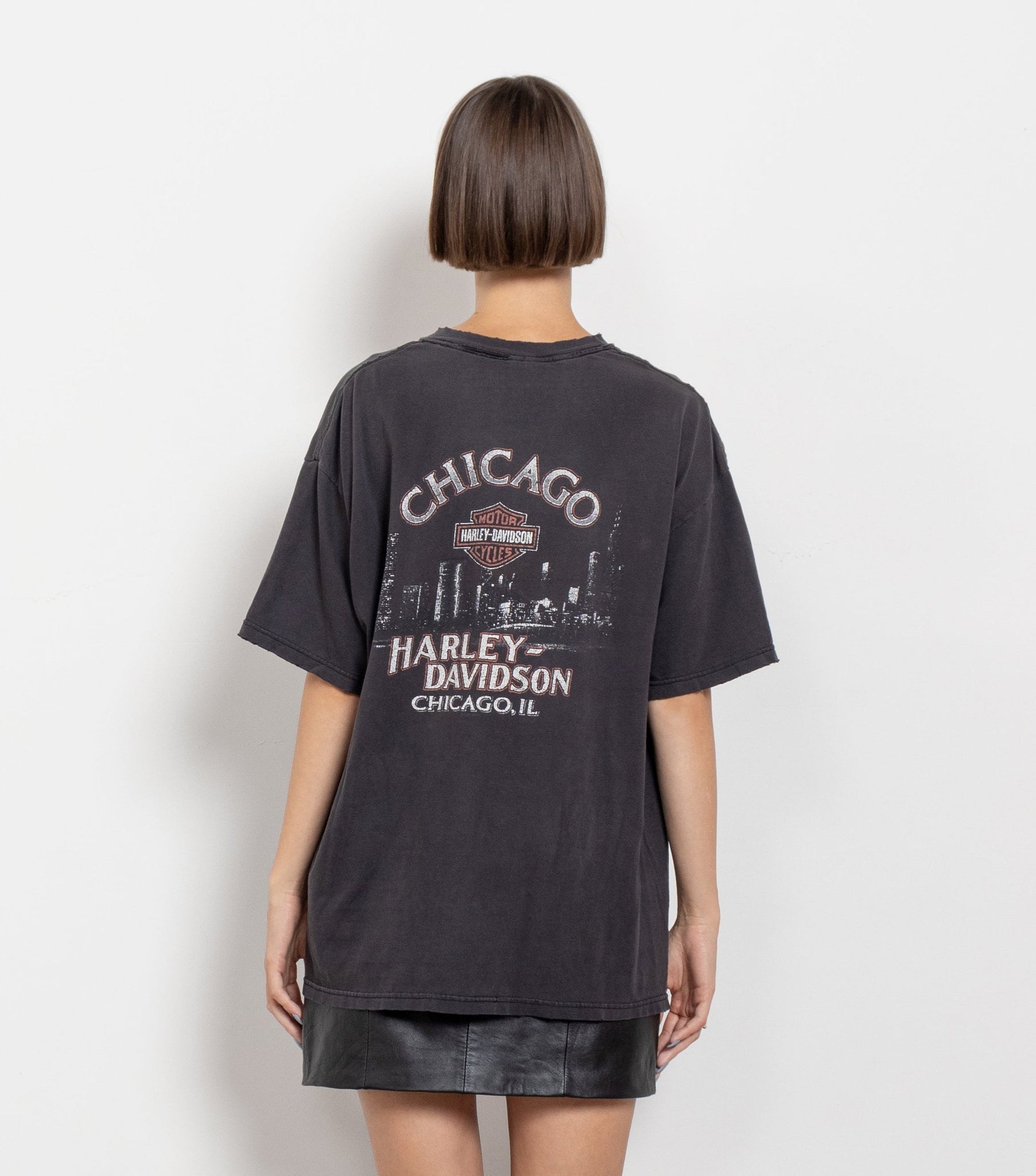 Person wearing a black Harley Davidson t-shirt with 'Chicago' printed on the back.