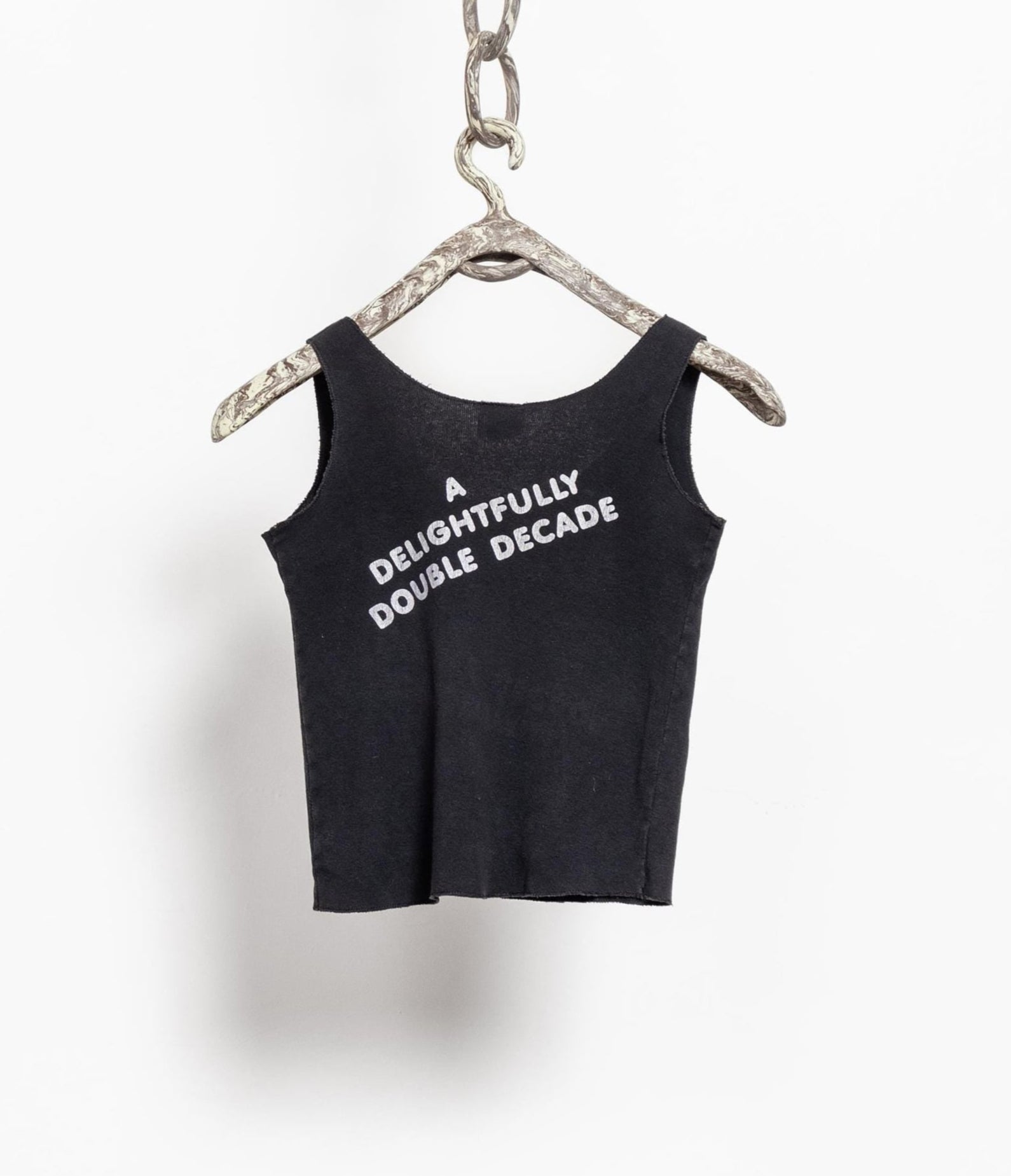 Black tank top with white text on a hanger against a white background