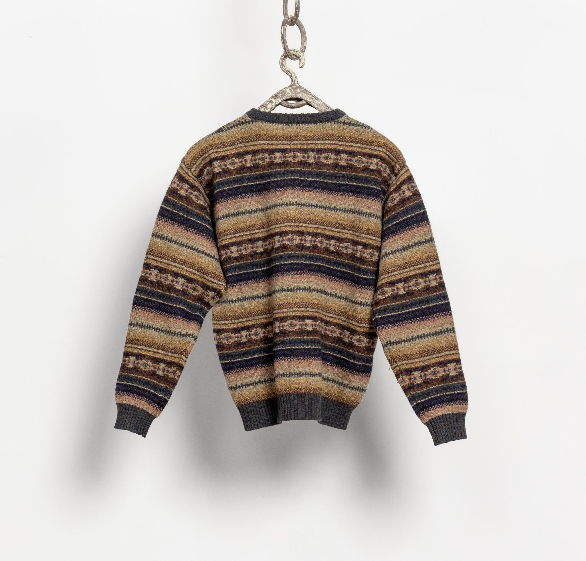 Striped sweater on a hanger against a white background