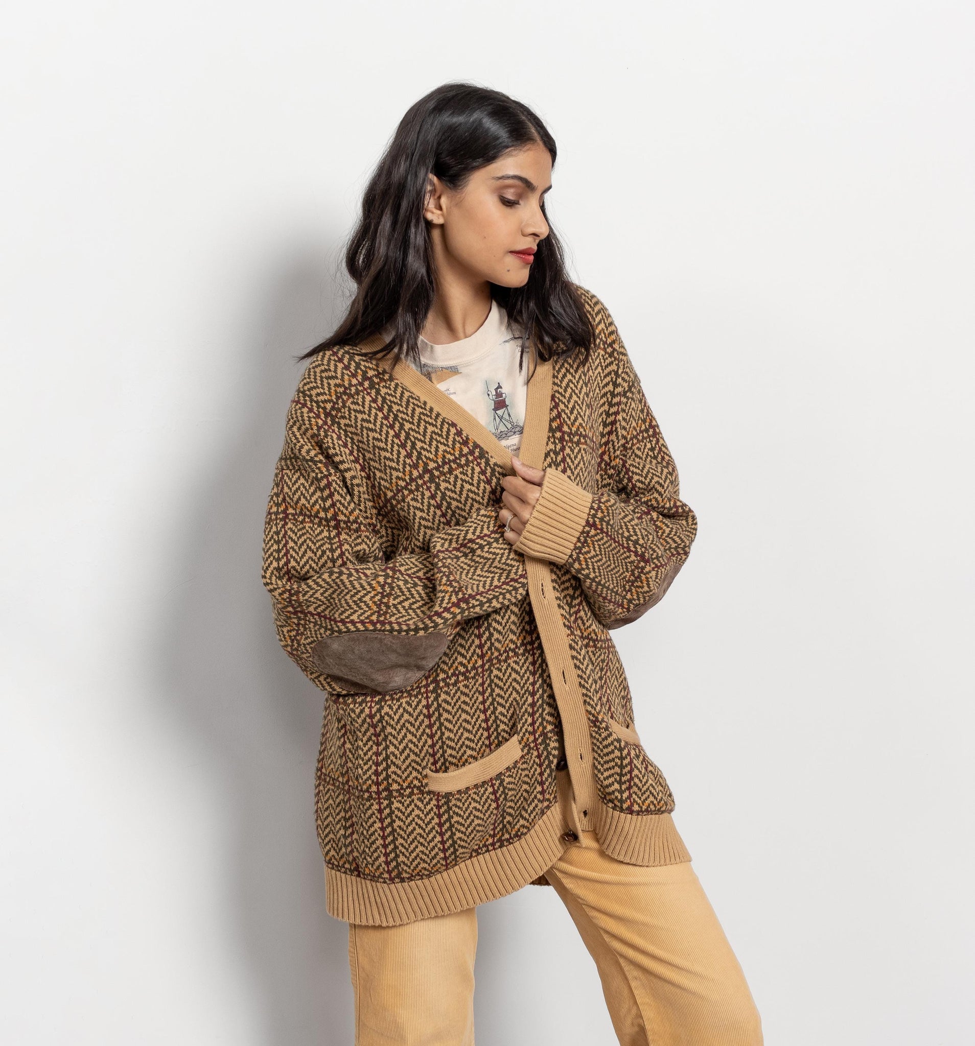 Woman wearing a brown knitted cardigan against a white background