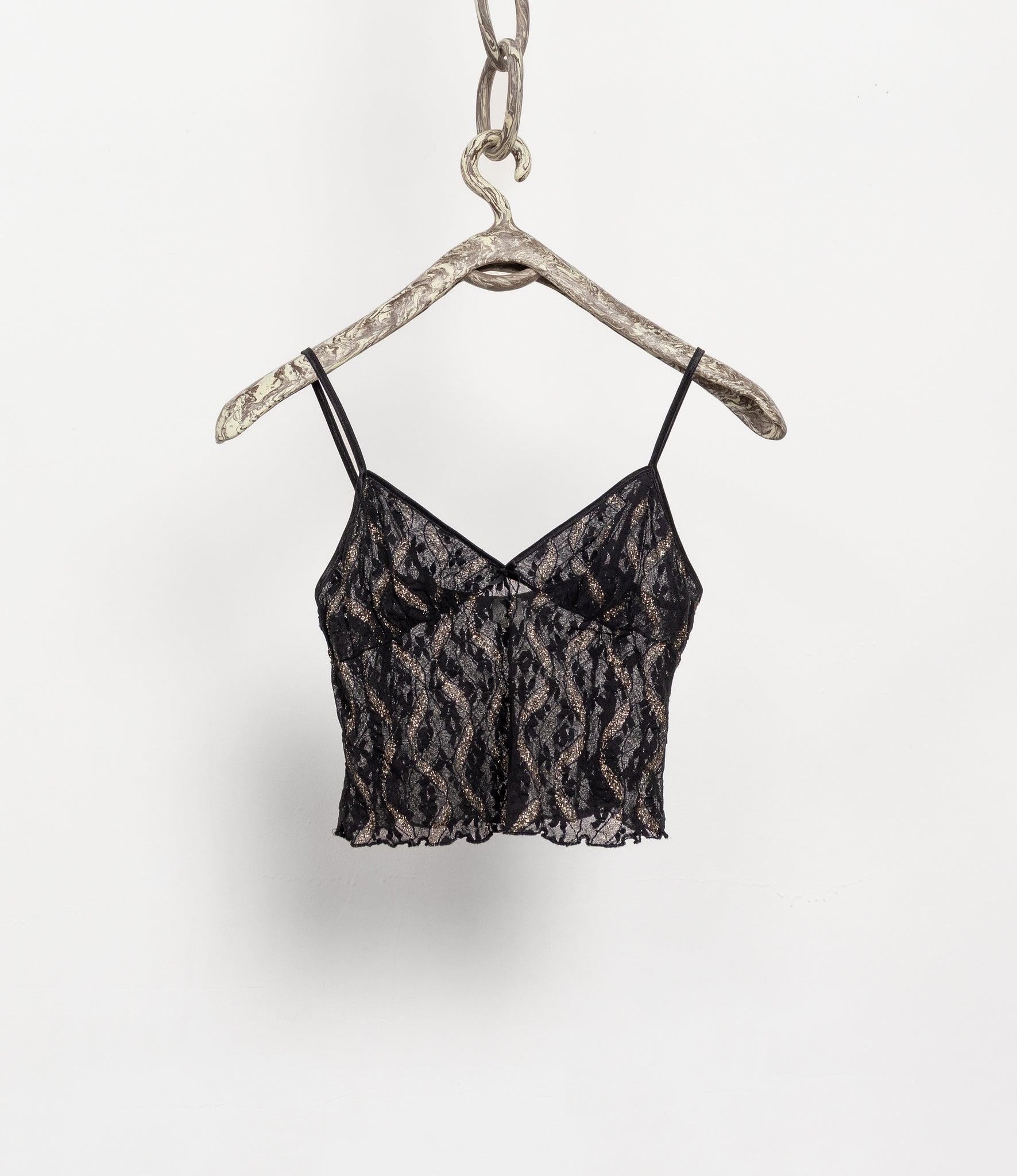 Black lace top on a hanger against a white background