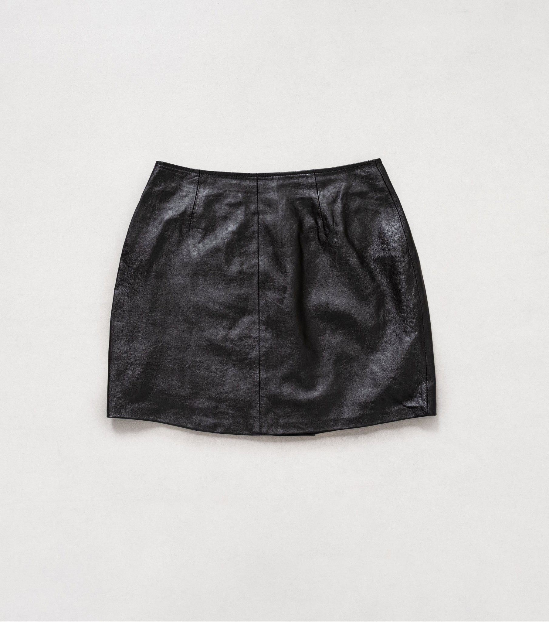 Black leather skirt on a light gray background