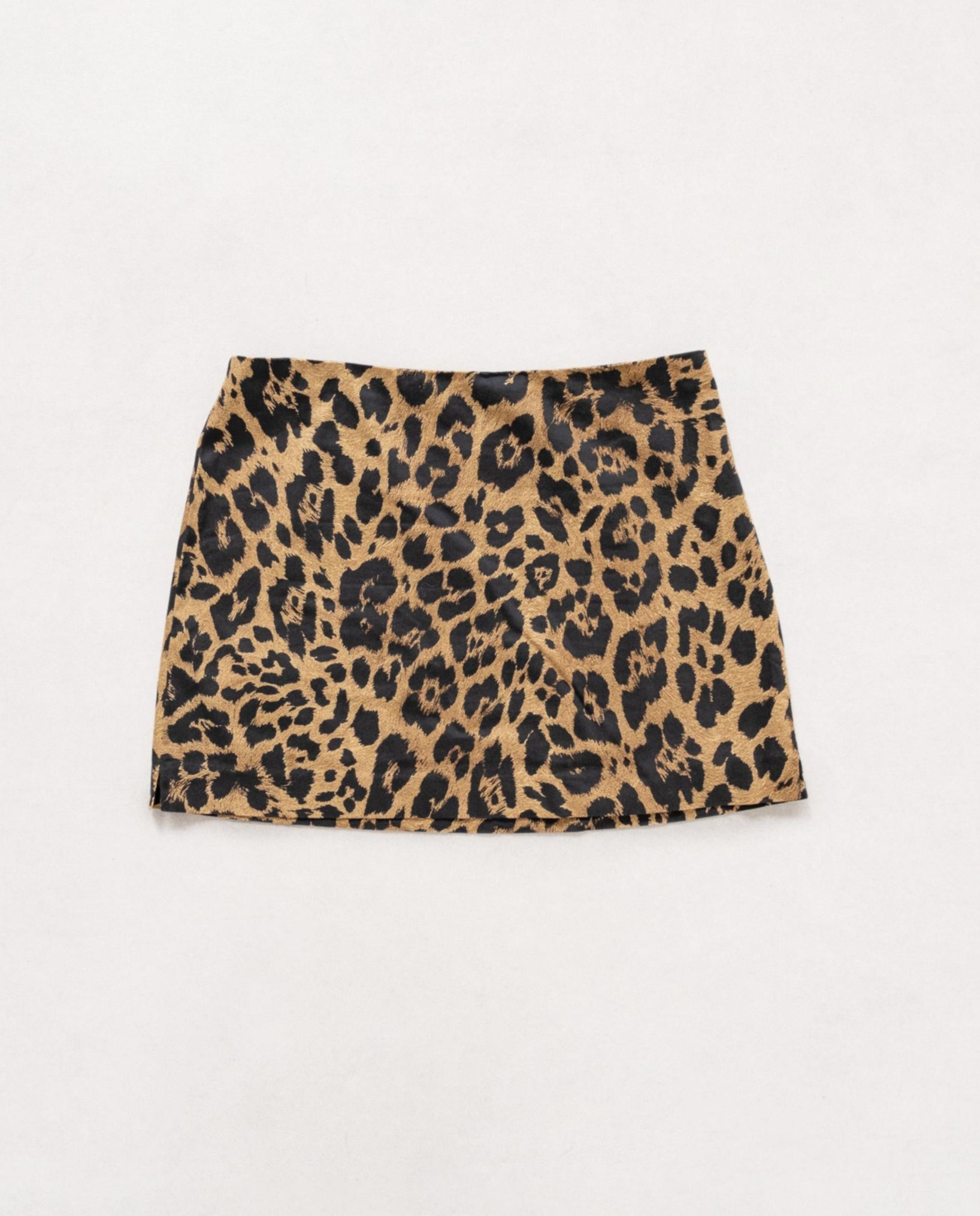 A vintage 90's high waisted leopard print mini skirt in beige, brown, and tan colors, displayed on a plain background.
