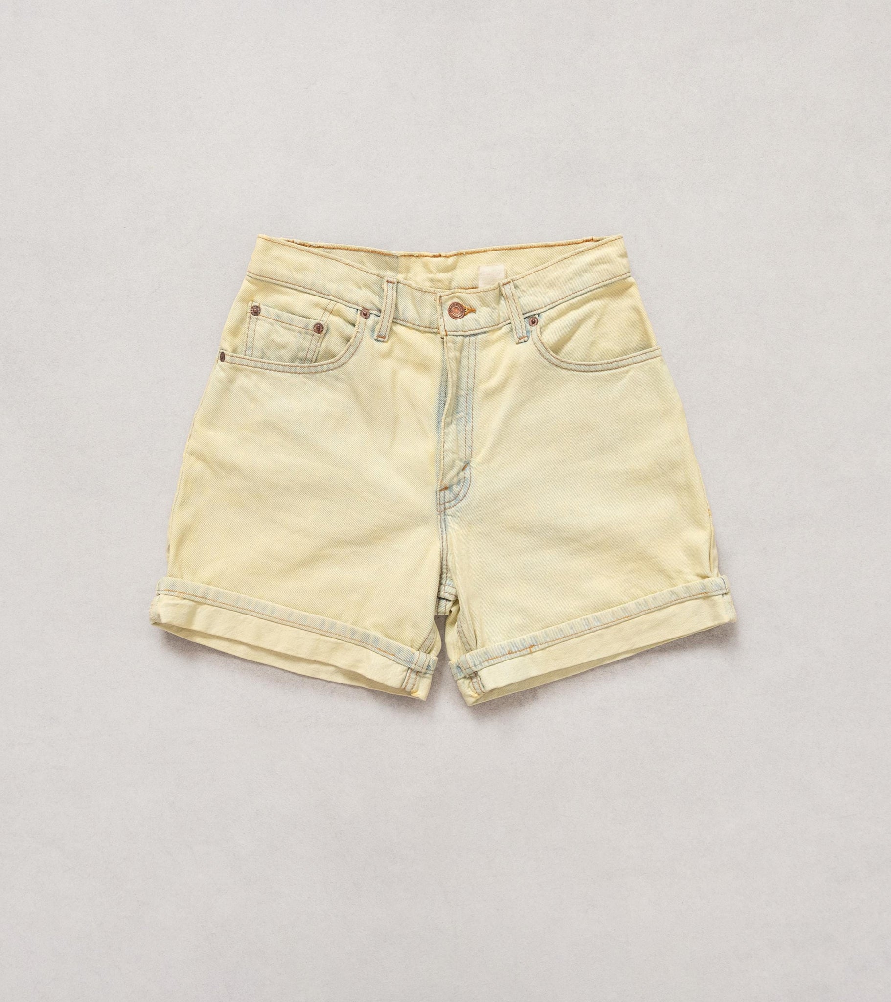 Light yellow denim shorts on a light gray background