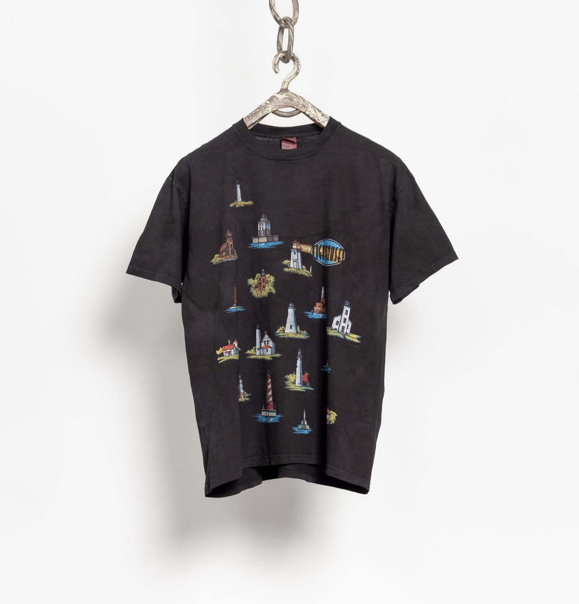 Black t-shirt with colorful graphic design on a hanger against a white background