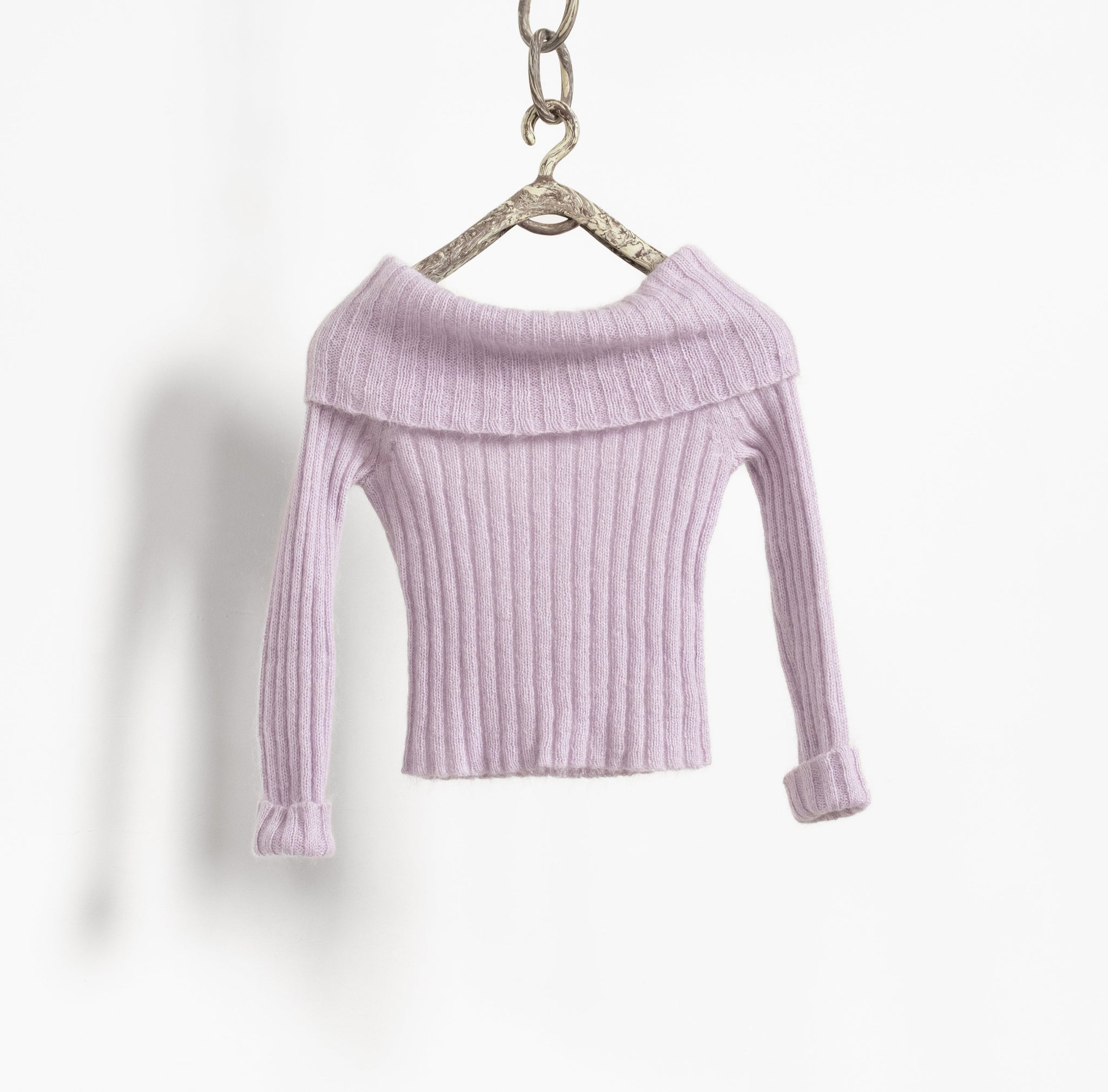 Lavender ribbed sweater on a hanger against a white background