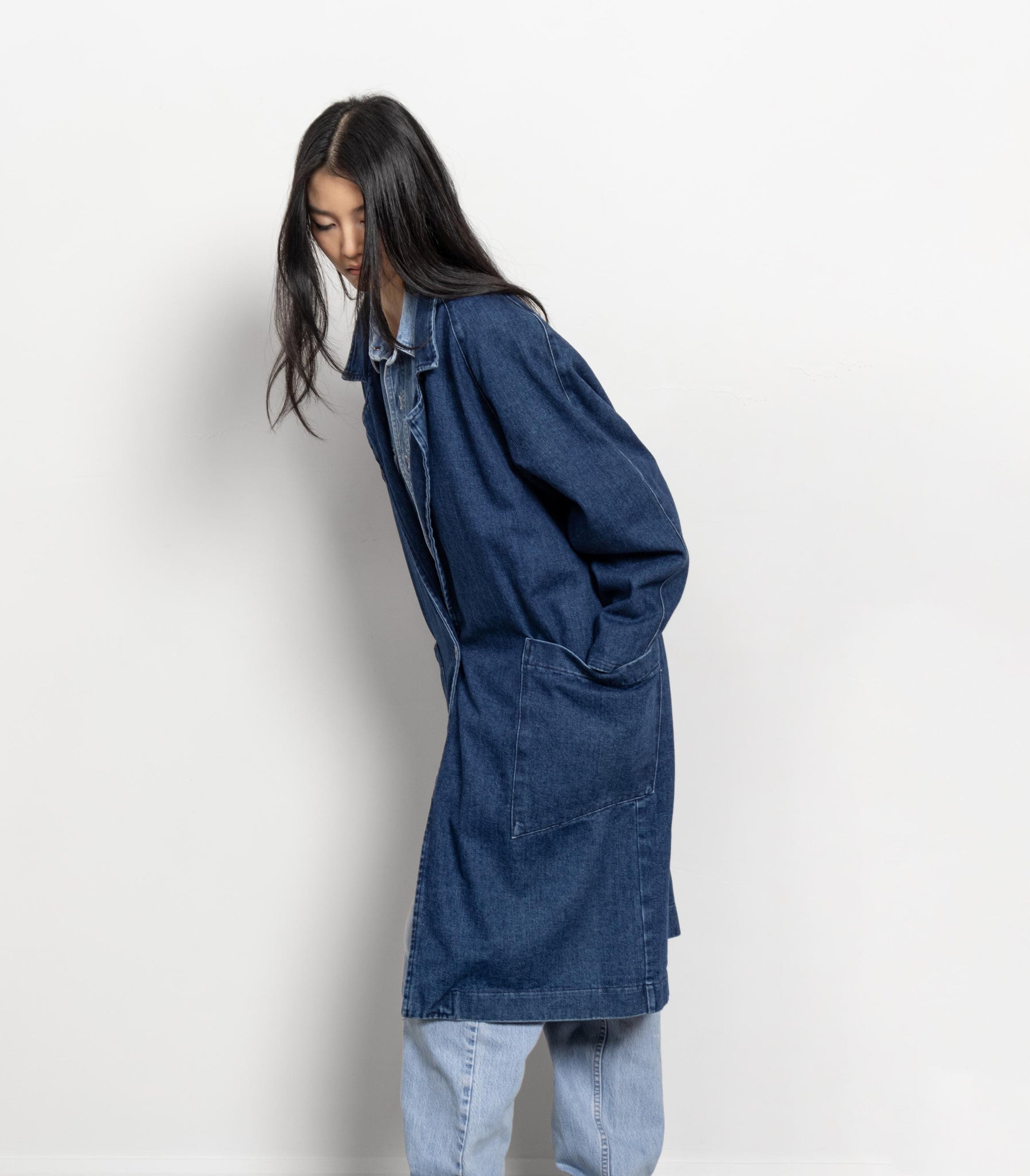 Person wearing a blue denim jacket on a white background