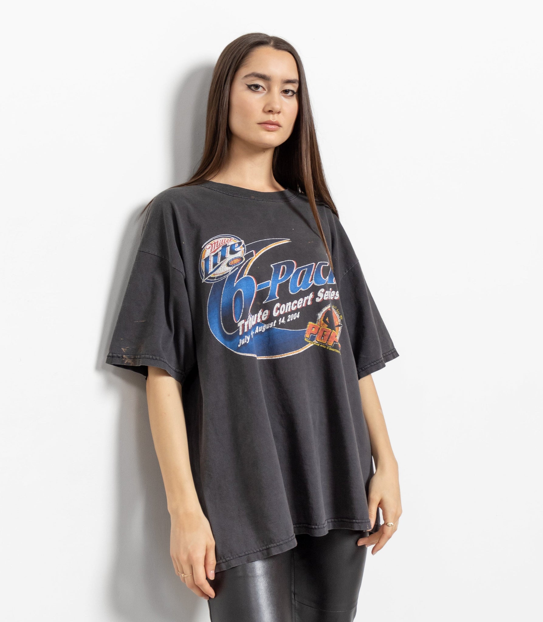 A person wearing a vintage Miller Lite concert t-shirt with a graphic print in the center, predominantly in gray color with some text and logo details.