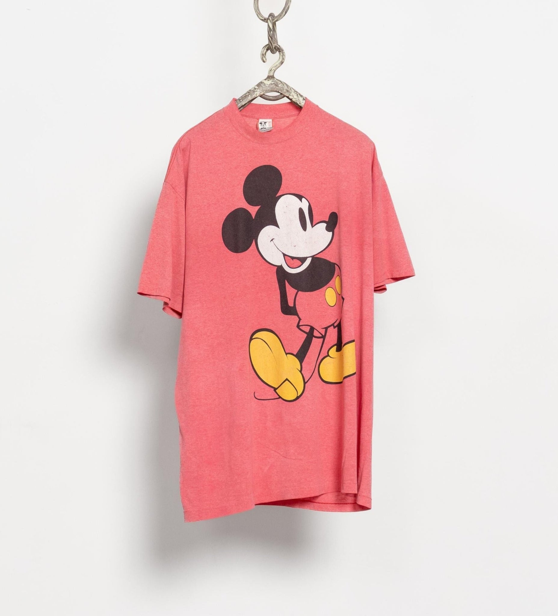 Pink t-shirt with a cartoon character on a hanger against a white background
