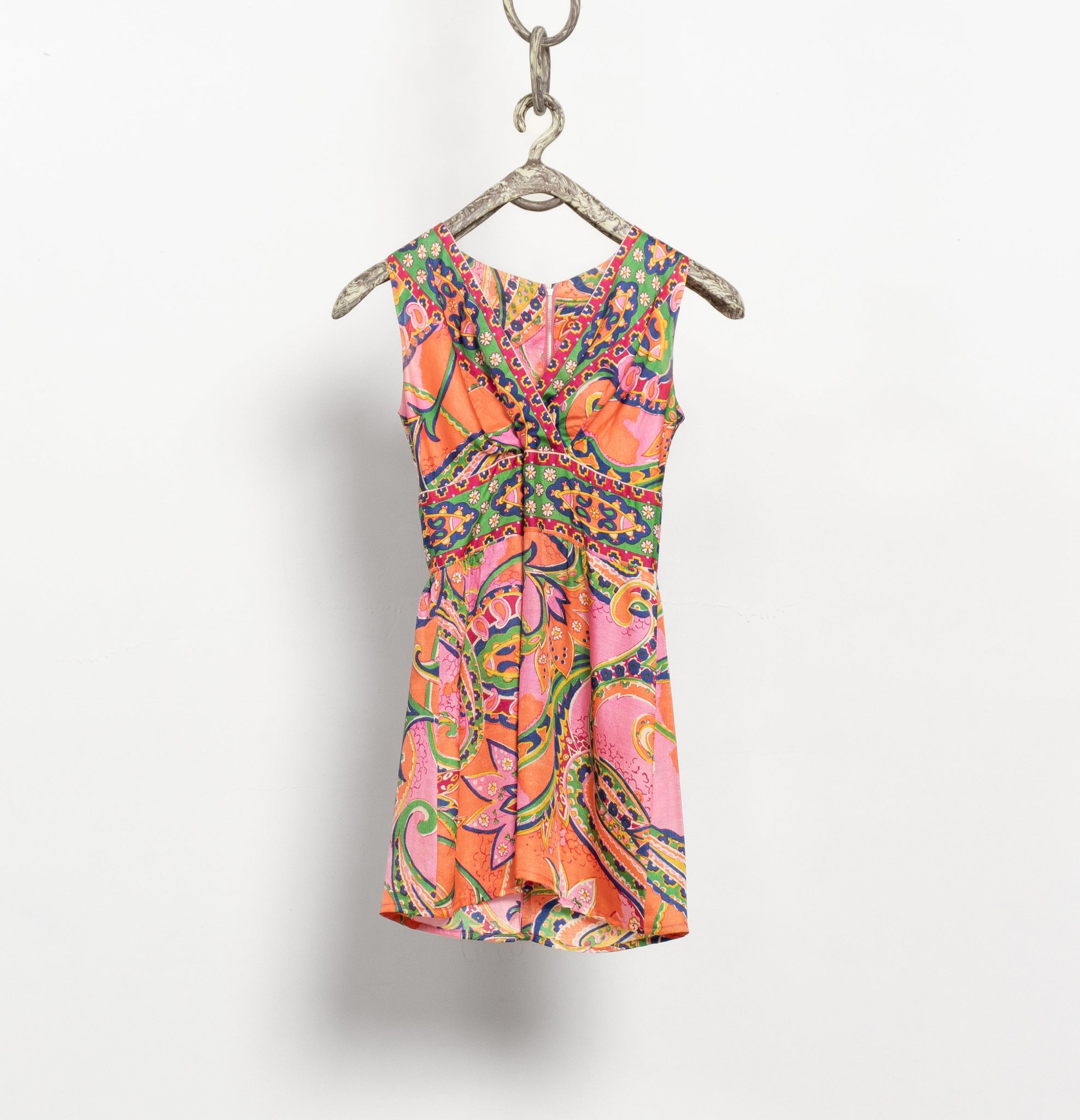 Colorful patterned dress on a hanger against a white background