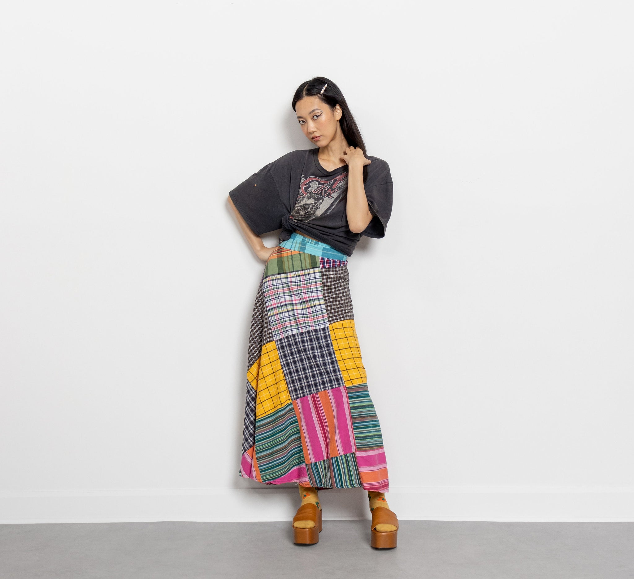 Woman wearing a colorful patchwork skirt against a white background