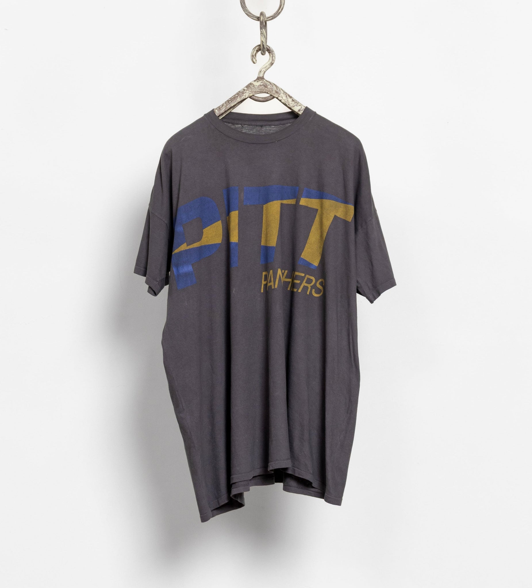 Gray t-shirt with 'PITT PANTHERS' text on a hanger against a white background