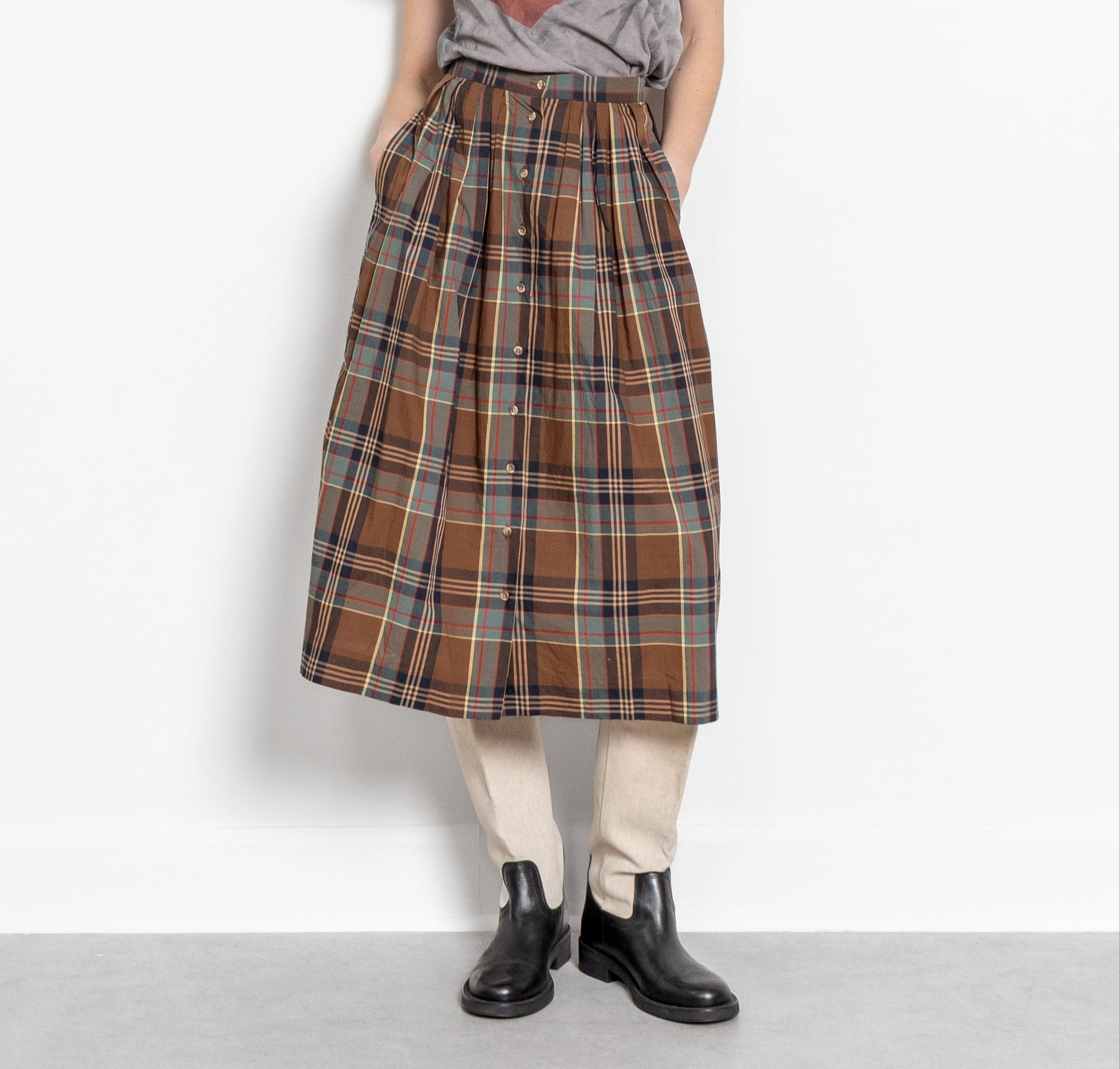 Person wearing a plaid skirt with a plain background