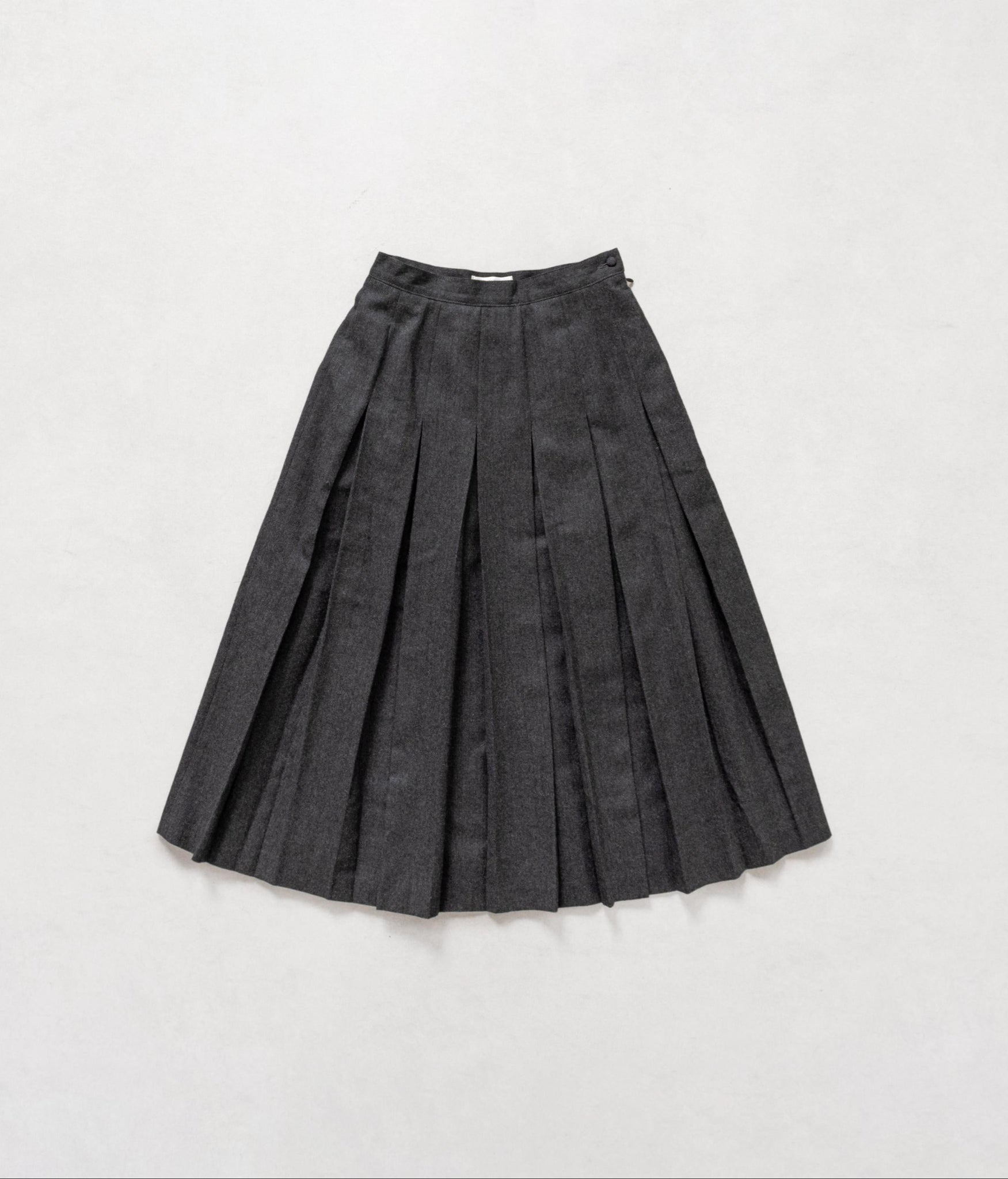 Dark gray pleated skirt on a light gray background