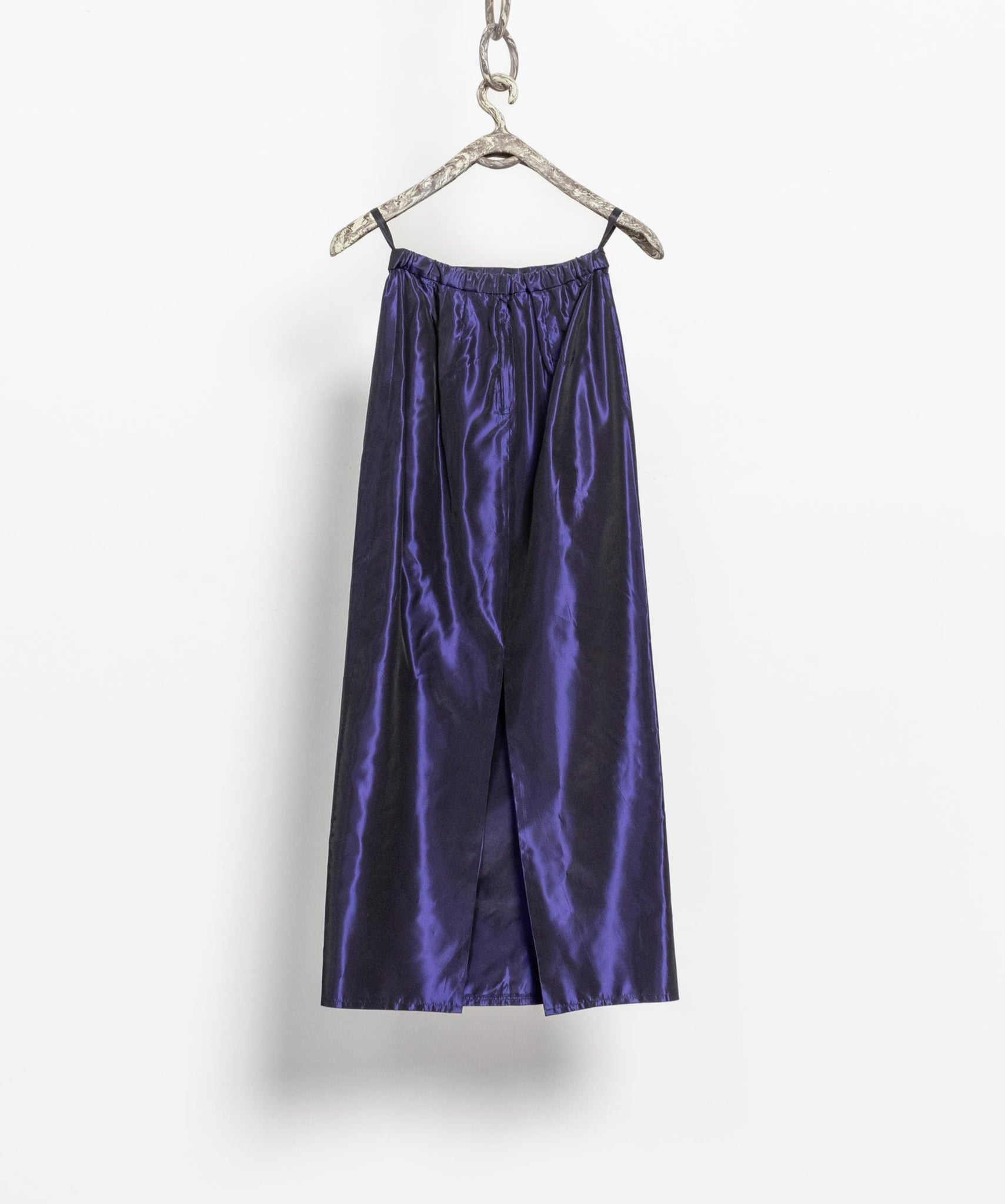 Purple satin pants on a hanger against a white background