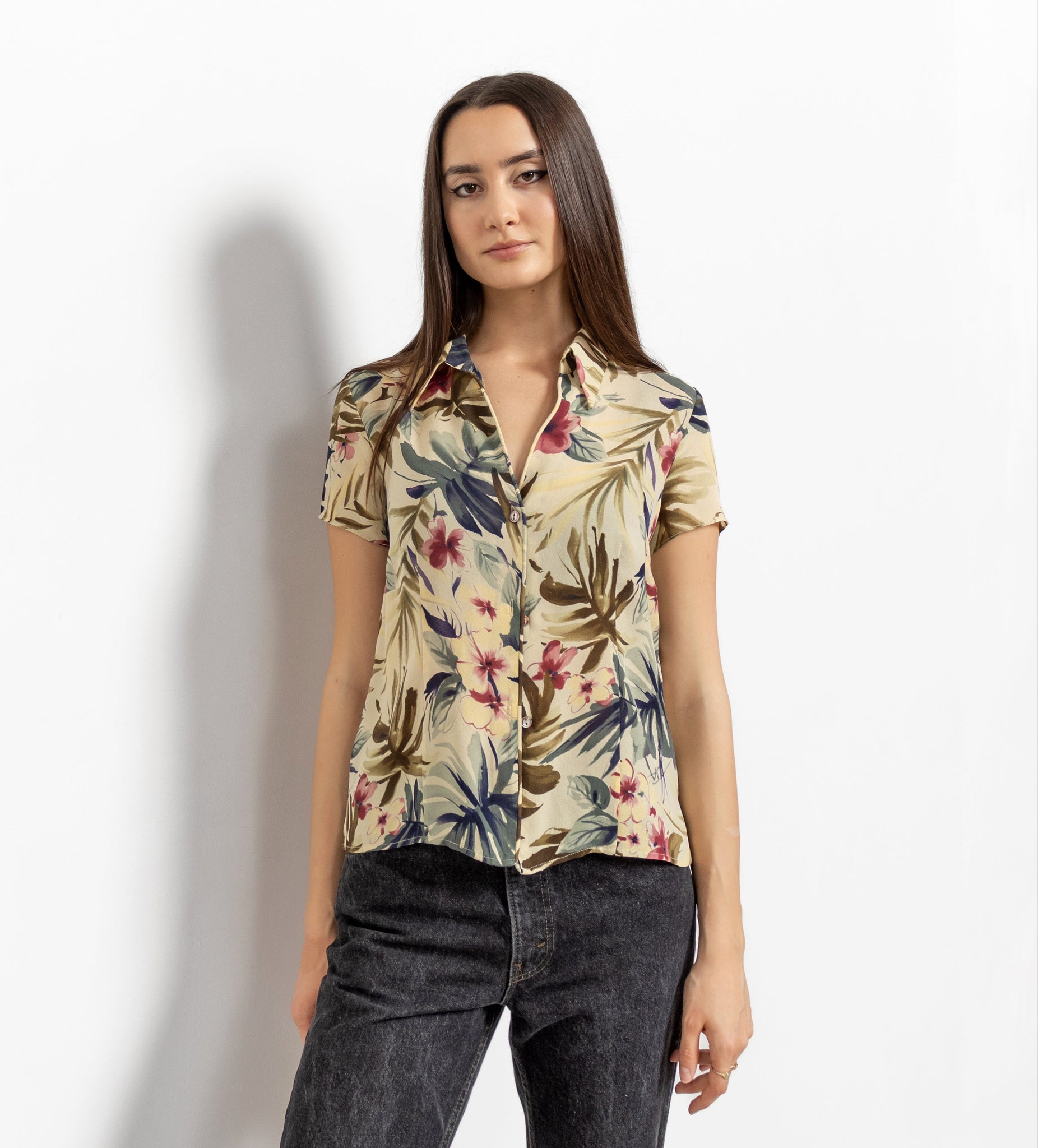 Woman wearing a floral short-sleeve shirt against a white background