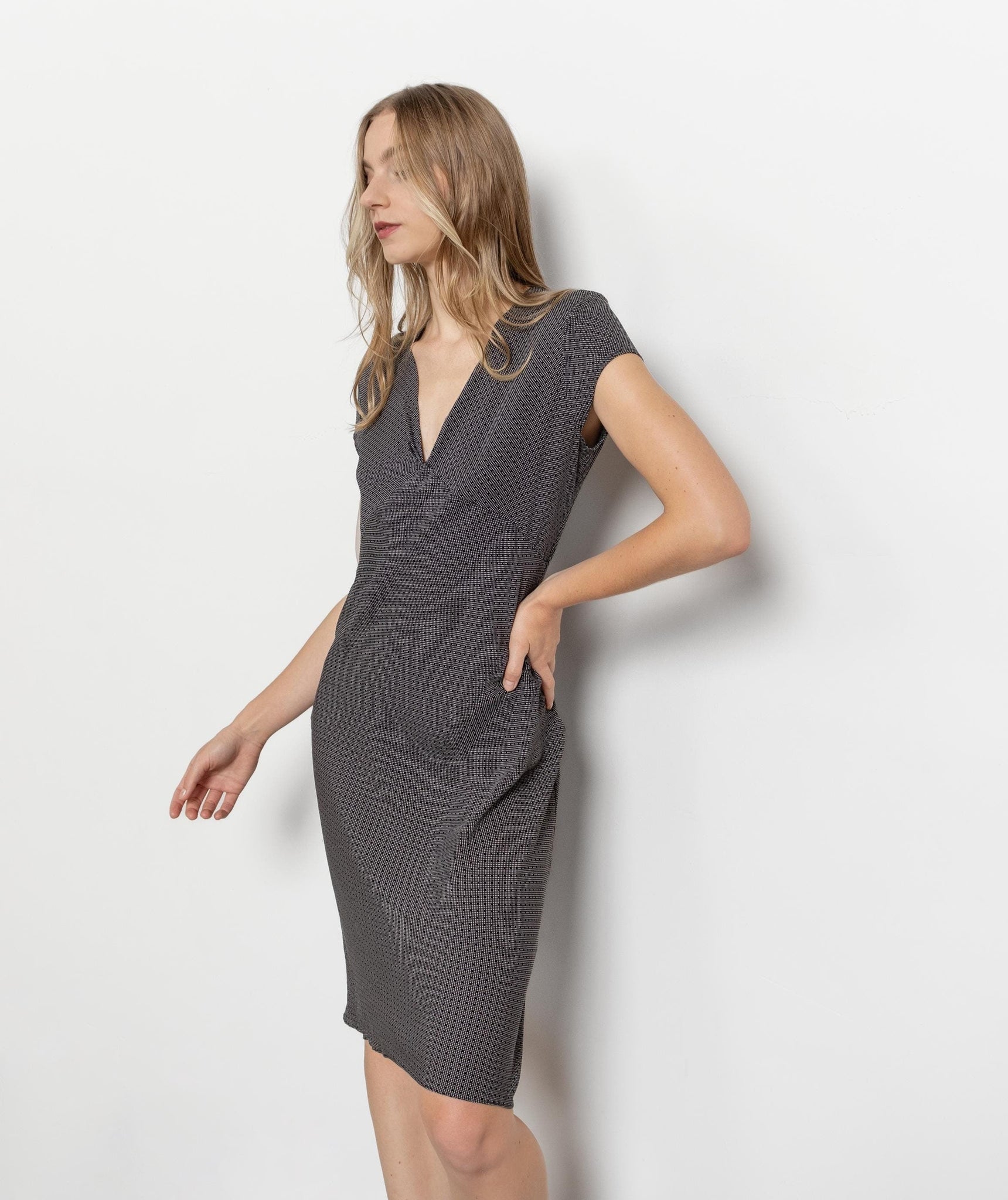 A vintage black silk dress with a round neckline and sleeveless design, displayed on a model against a white background.