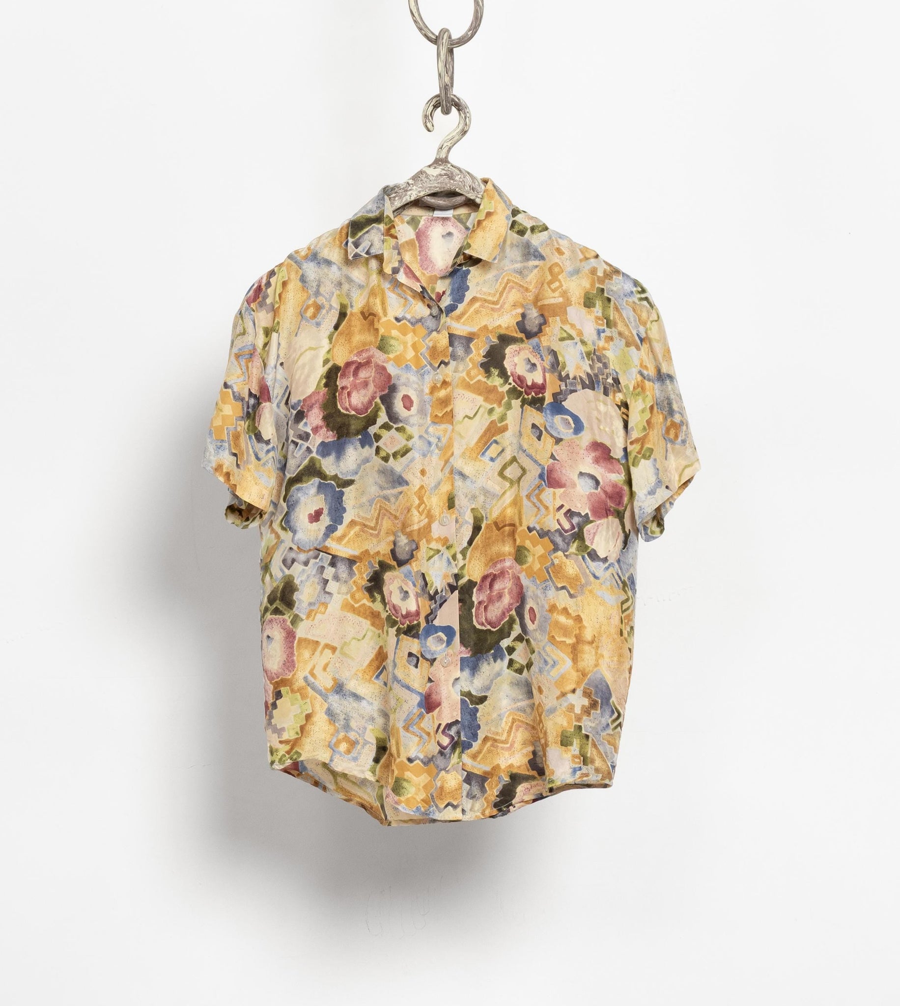 Floral patterned shirt on a hanger against a white background