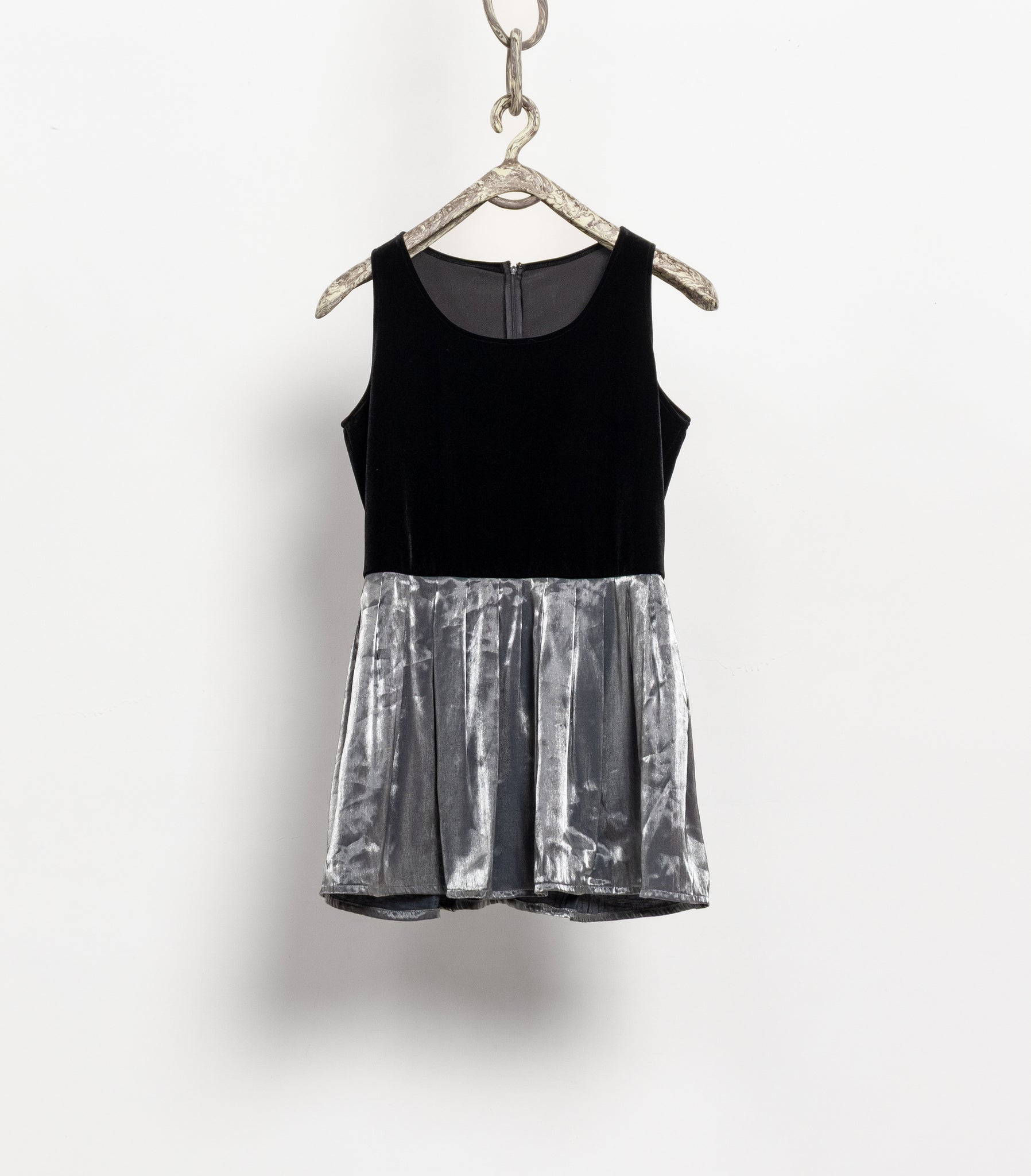 Black and silver dress on a hanger against a white background