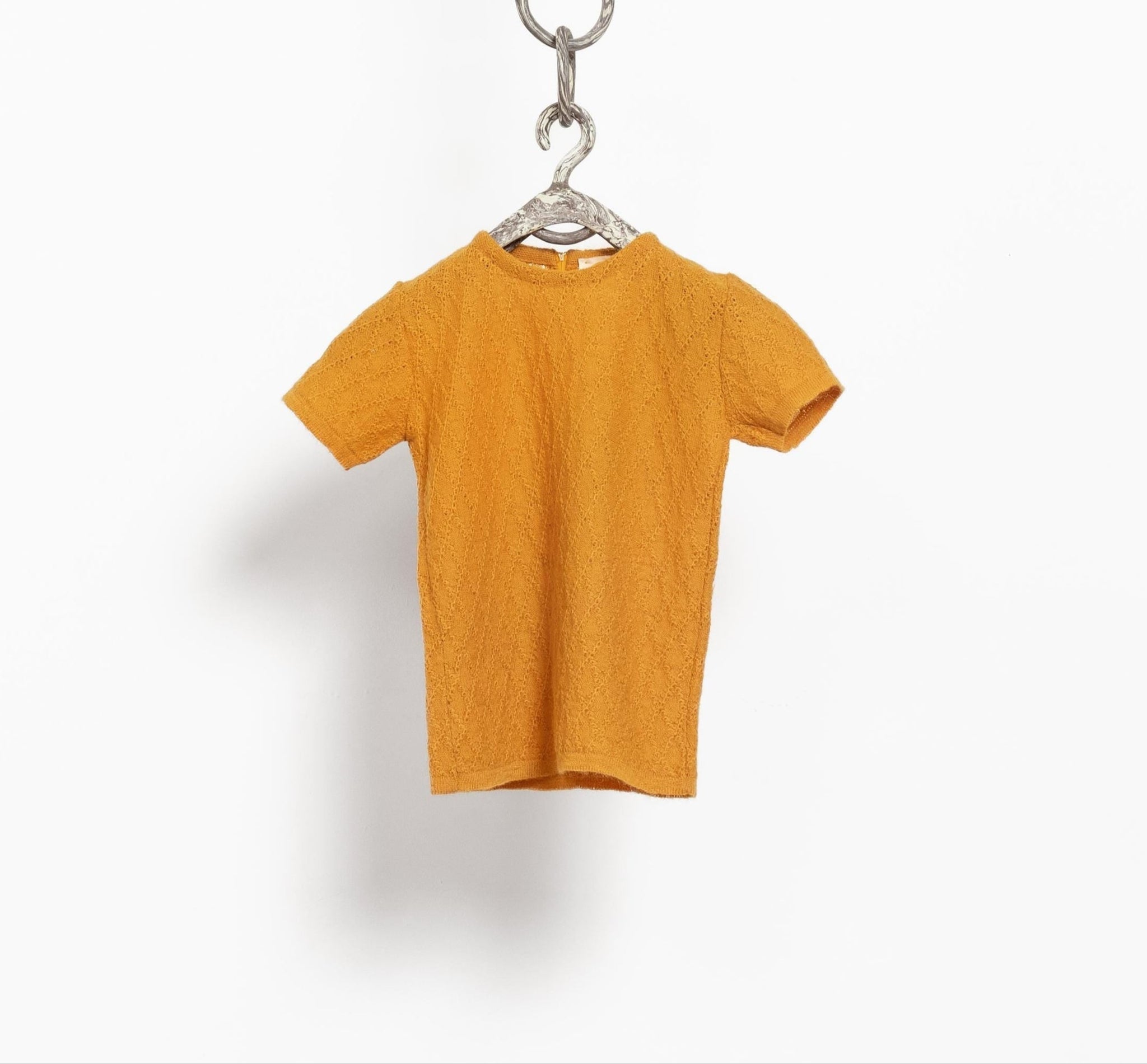 Yellow t-shirt on a hanger against a white background
