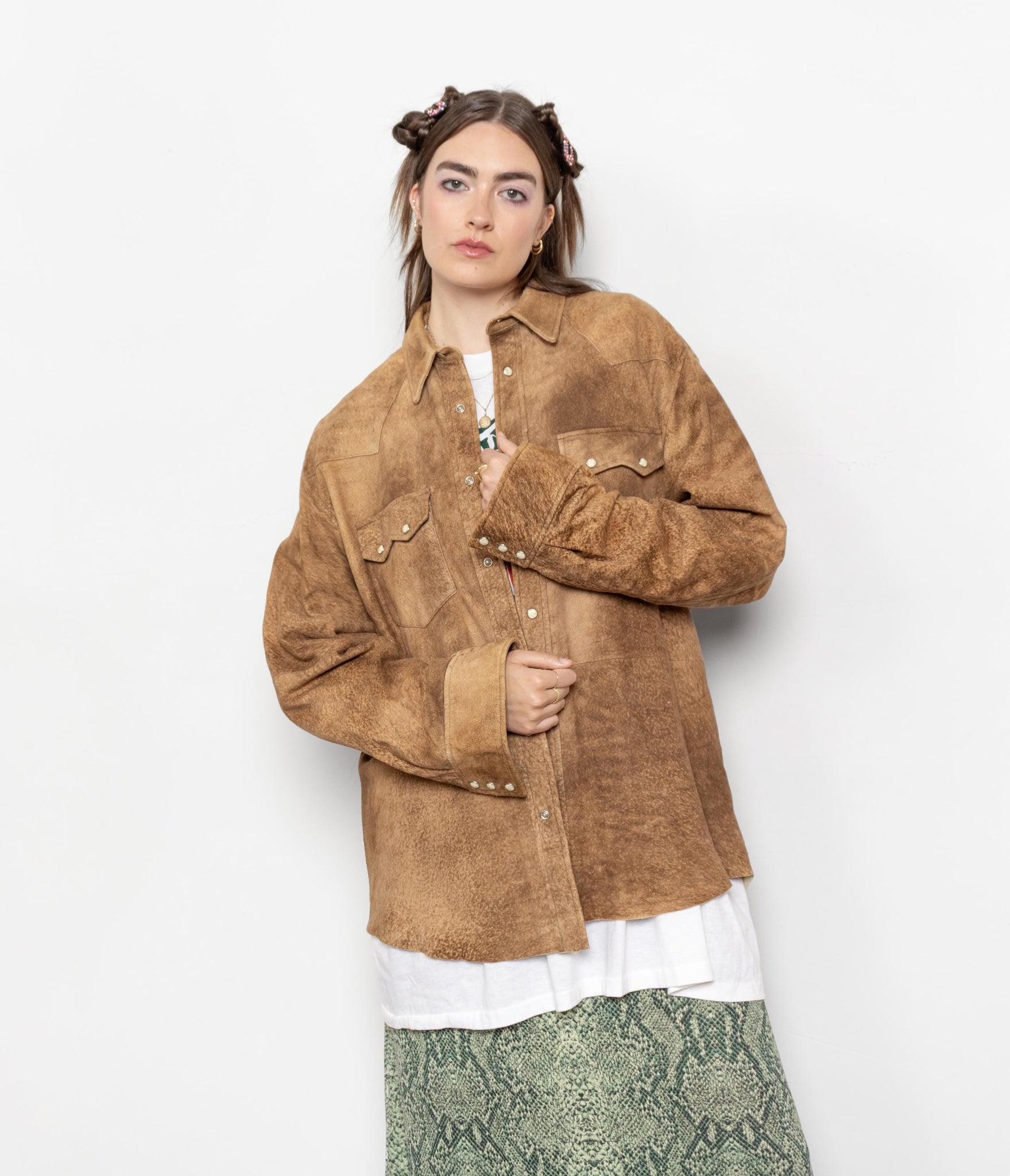 Person wearing a brown suede jacket on a white background