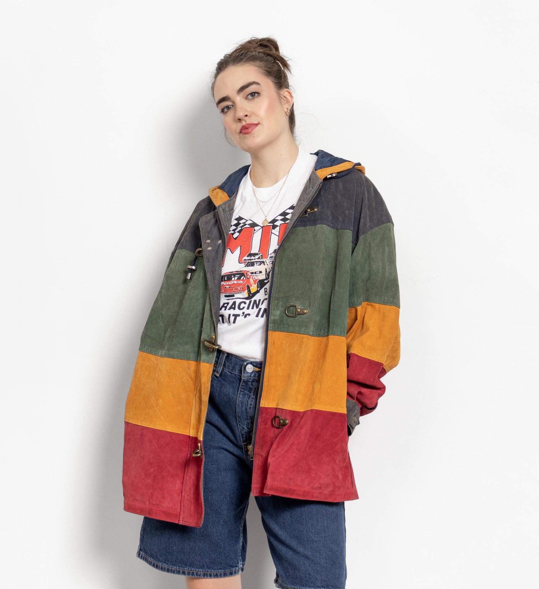 Person wearing a colorful patchwork jacket on a white background
